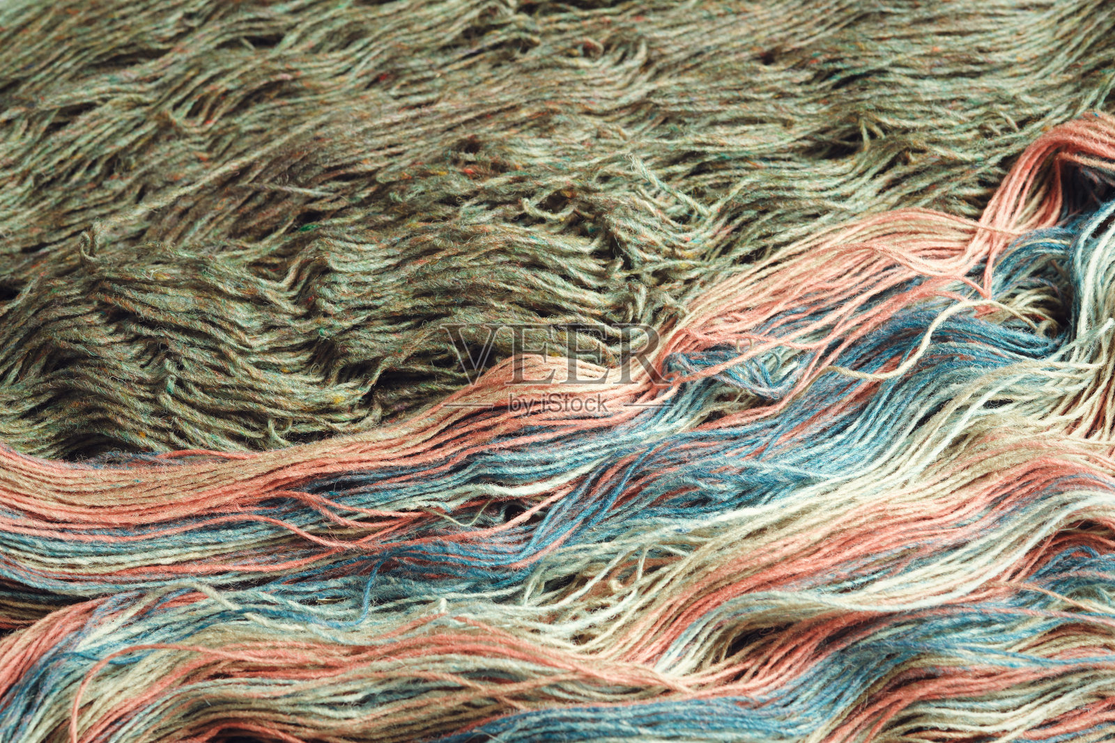 线来自天然有机羊毛。两束未缠绕的绿色和彩虹针织纱。照片摄影图片