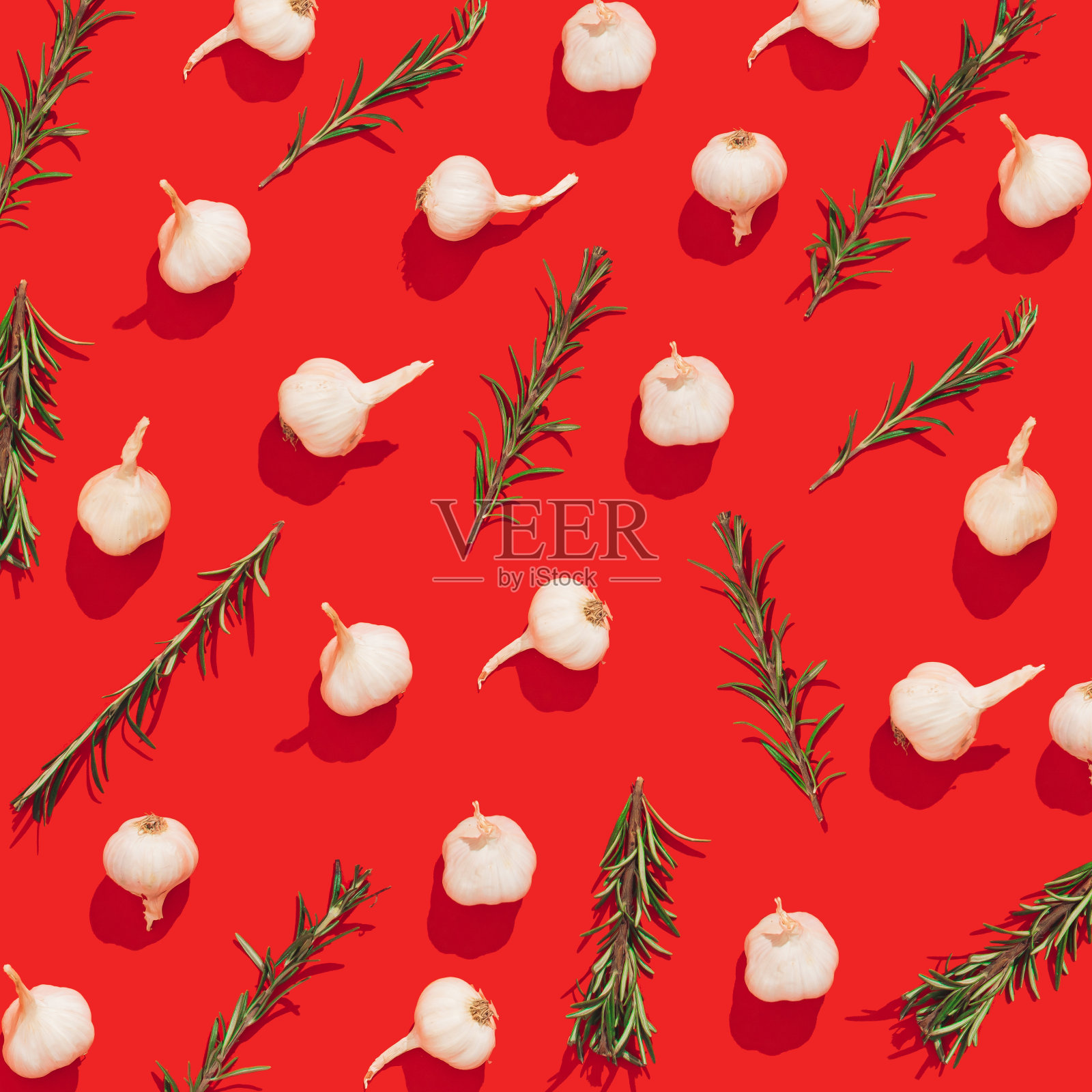 彩色无缝图案与大蒜和迷迭香在红色背景。热的、健康的或芳香的食物的创意概念。照片摄影图片