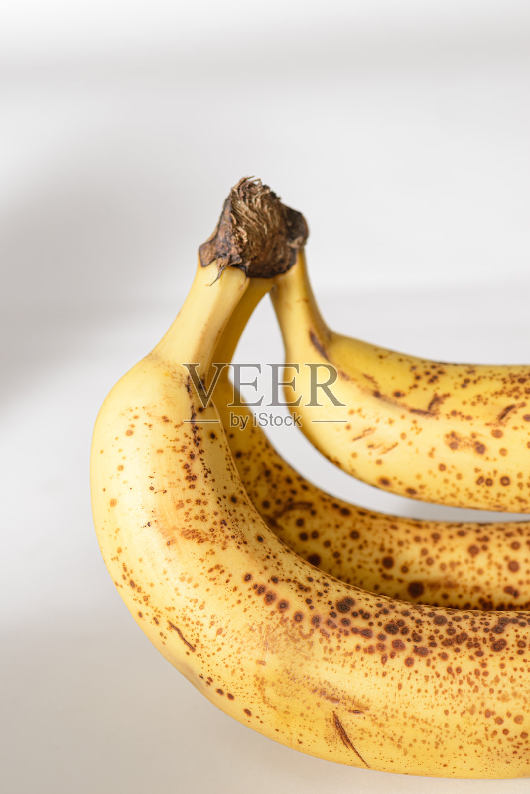 白色背景上一串成熟的香蕉照片摄影图片