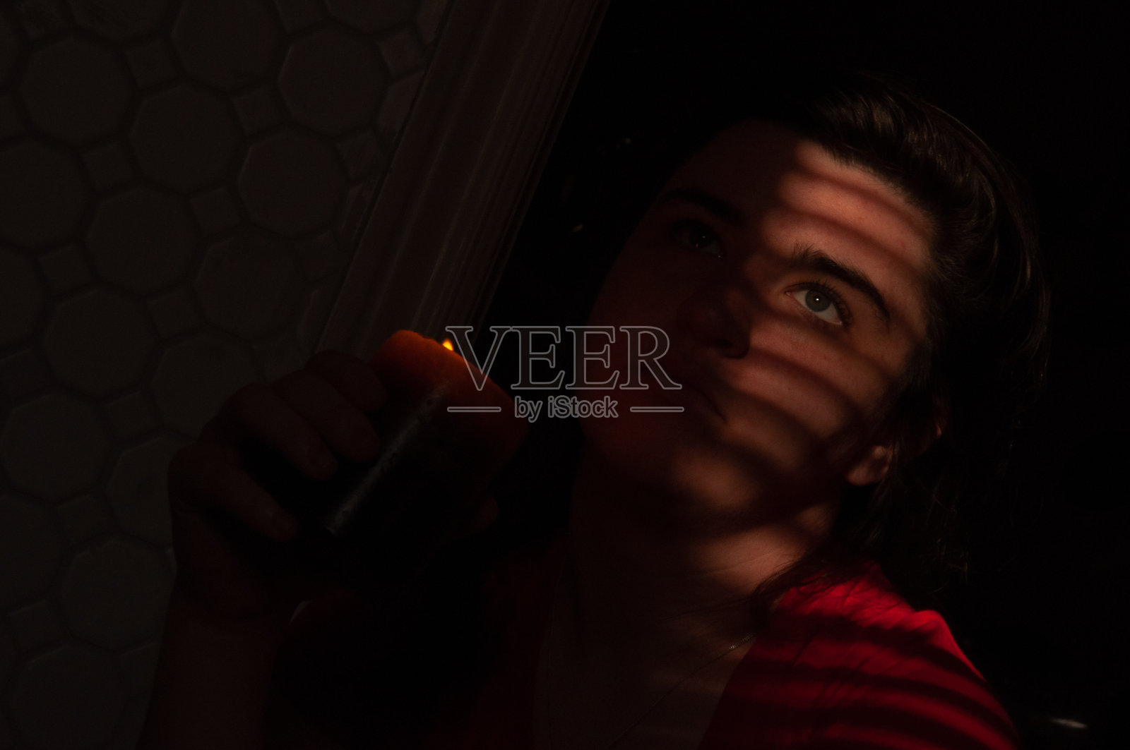 百叶帘在阳光照射下在女性脸上形成了线条照片摄影图片