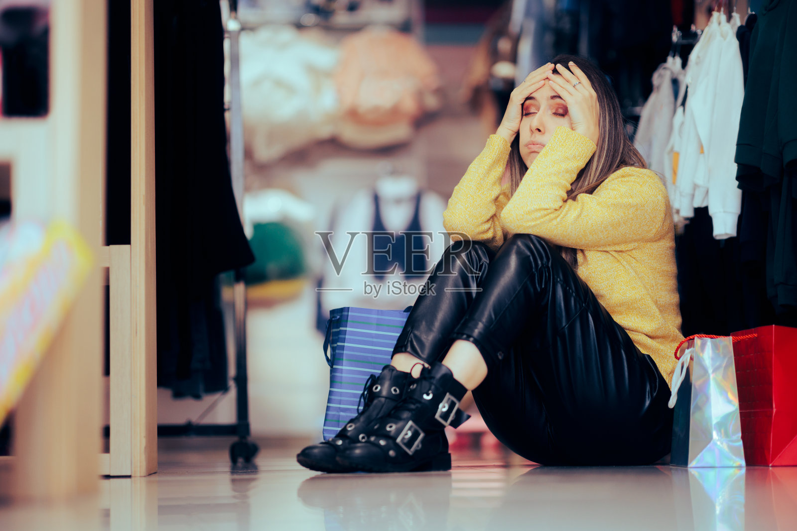 紧张的购物者坐在商店地板上感到疲倦照片摄影图片