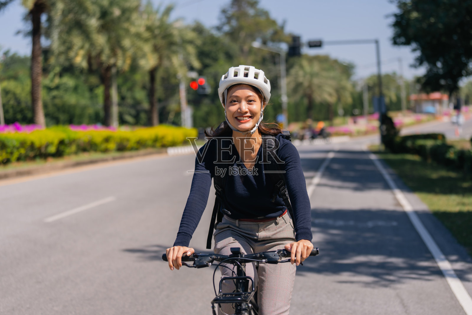 亚洲女性在好天气骑自行车上班照片摄影图片