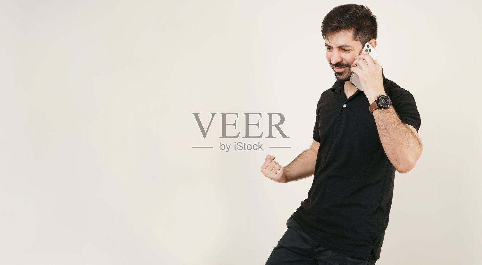 庆祝成功的人。《赢家》在手机上发表讲话。亚洲人、印度人或巴基斯坦人在电话里说“是”。胜利手势。获胜者随时待命。兴奋快乐的人随叫随到。黑色的衬衫。本空间照片摄影图片