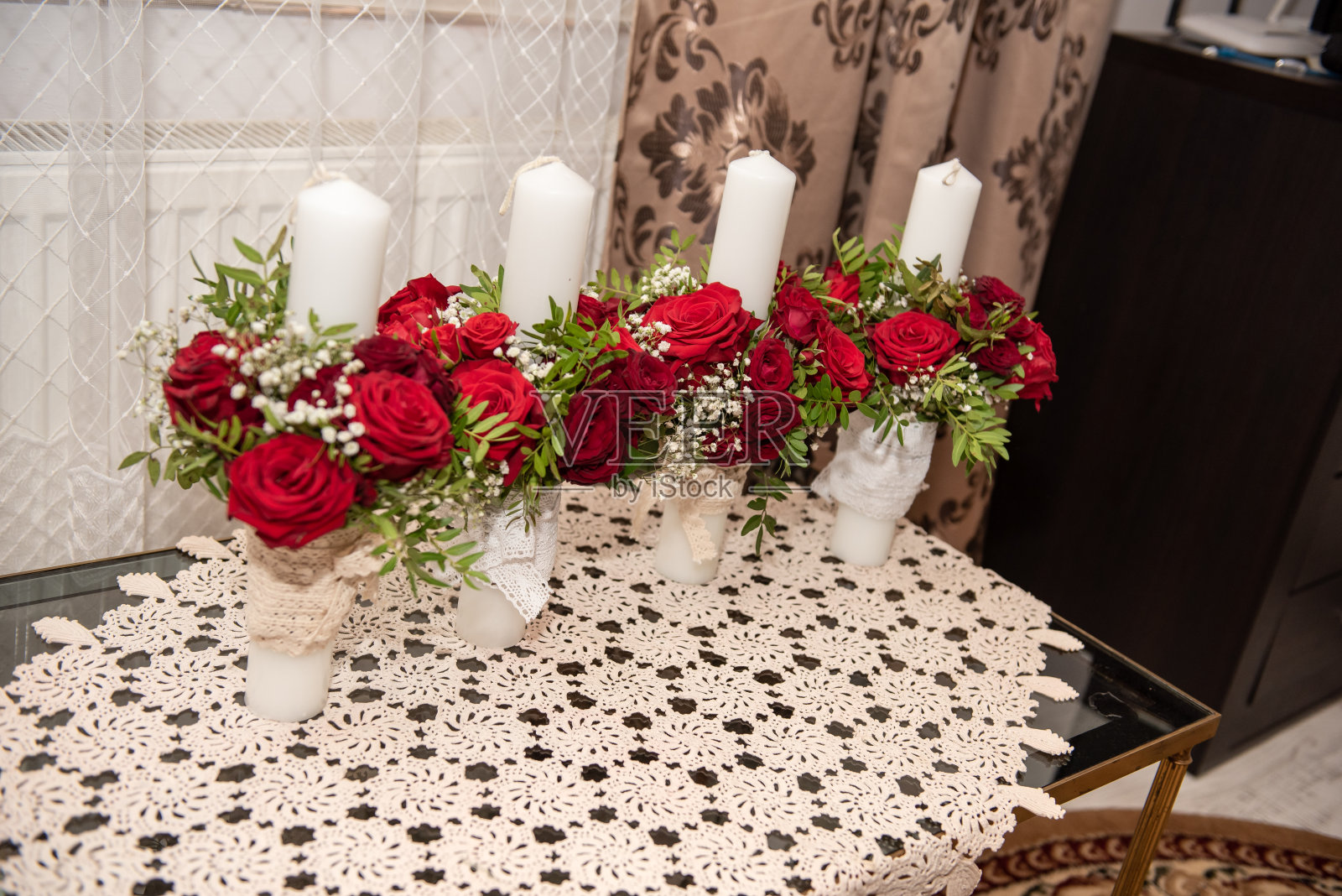 4支用红花装饰的洗礼蜡烛照片摄影图片