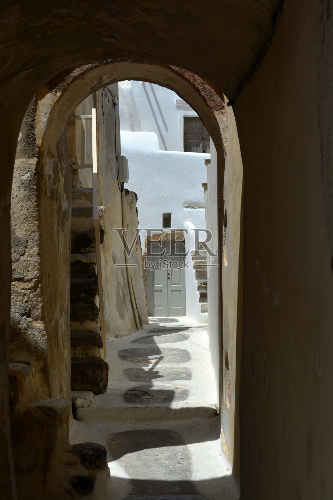 狭窄的弧形小巷，在夏天风景如画，绿树成荫，Emporio，“Mesana”区，圣托里尼，希腊，欧洲照片摄影图片