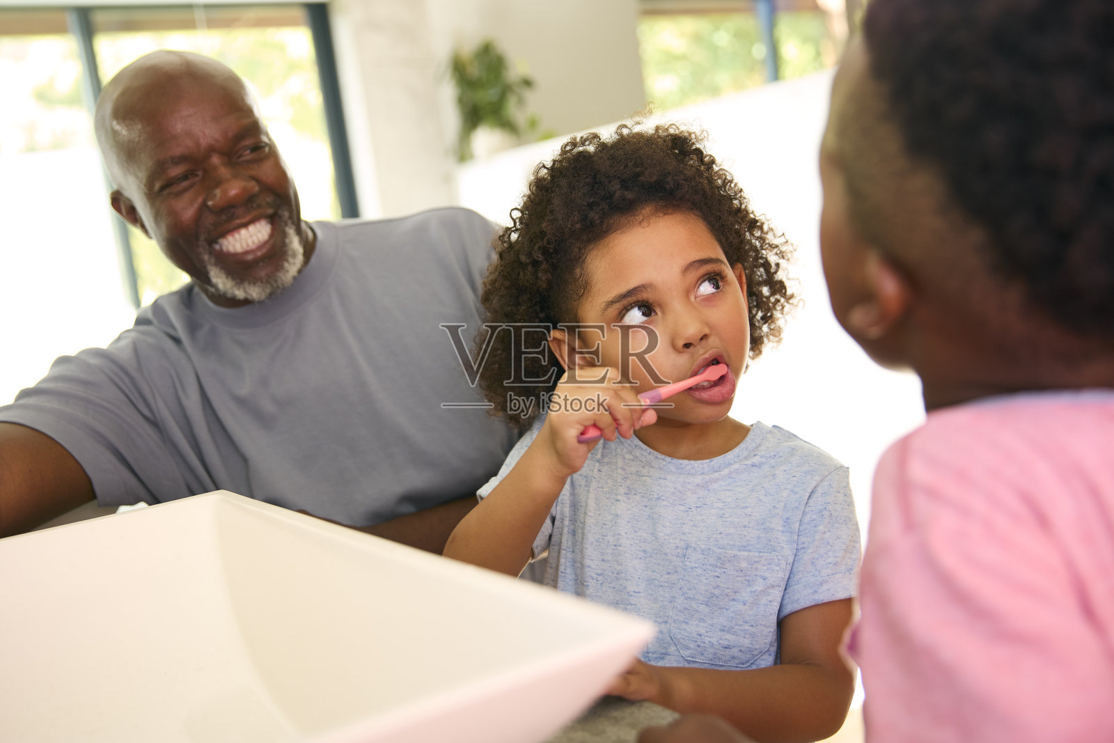 爷爷在睡觉前帮孙子在家里的浴室刷牙照片摄影图片