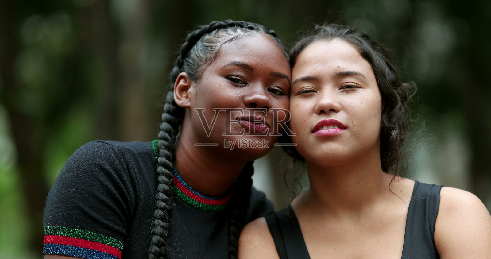 不同种族的女朋友一起摆姿势。非洲和西班牙女孩照片摄影图片