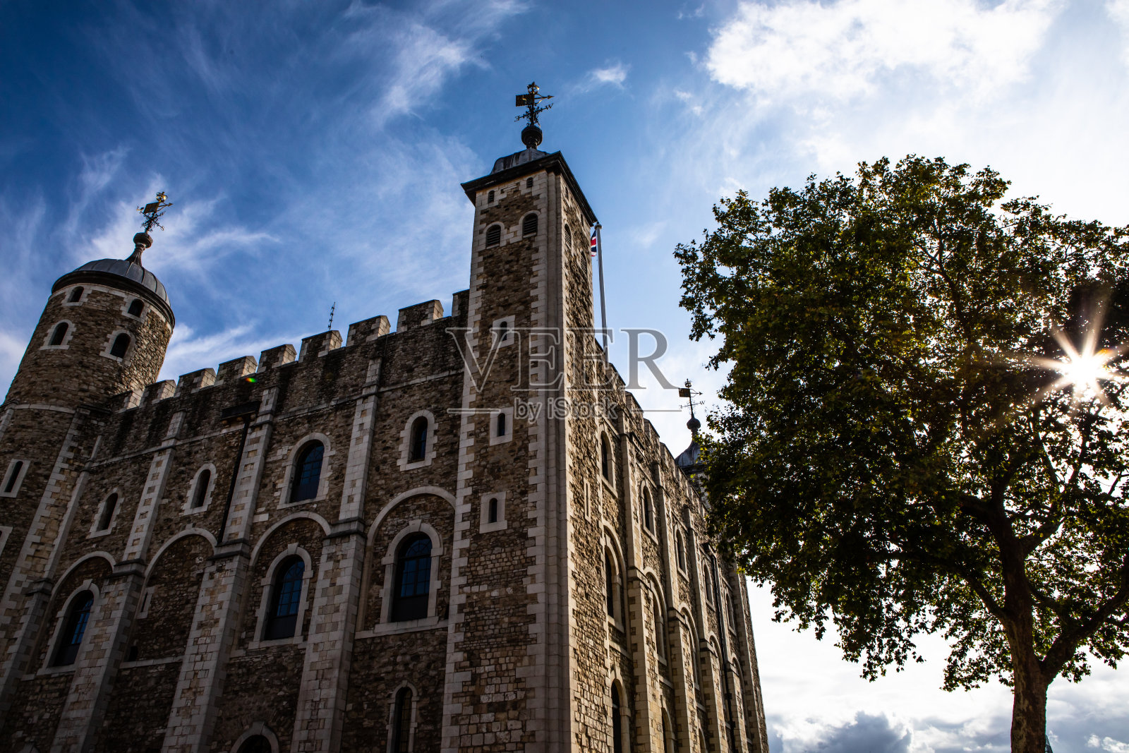 英国伦敦塔，蓝天，太阳耀斑在树上照片摄影图片