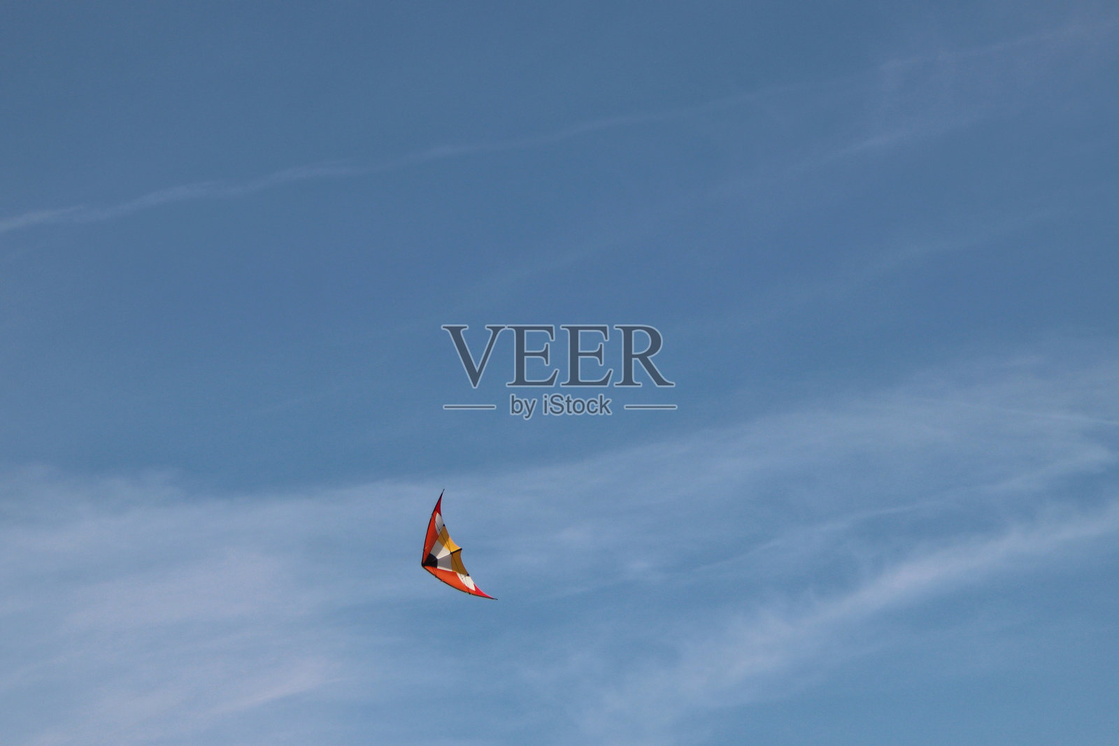 蓝色天空中的橙色特技风筝照片摄影图片