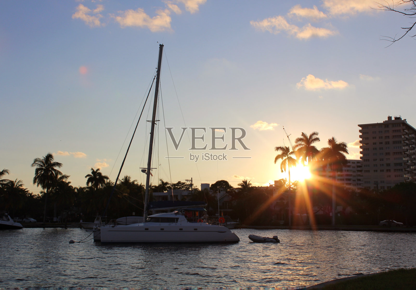 船停在河上，映衬着美丽的夕阳照片摄影图片