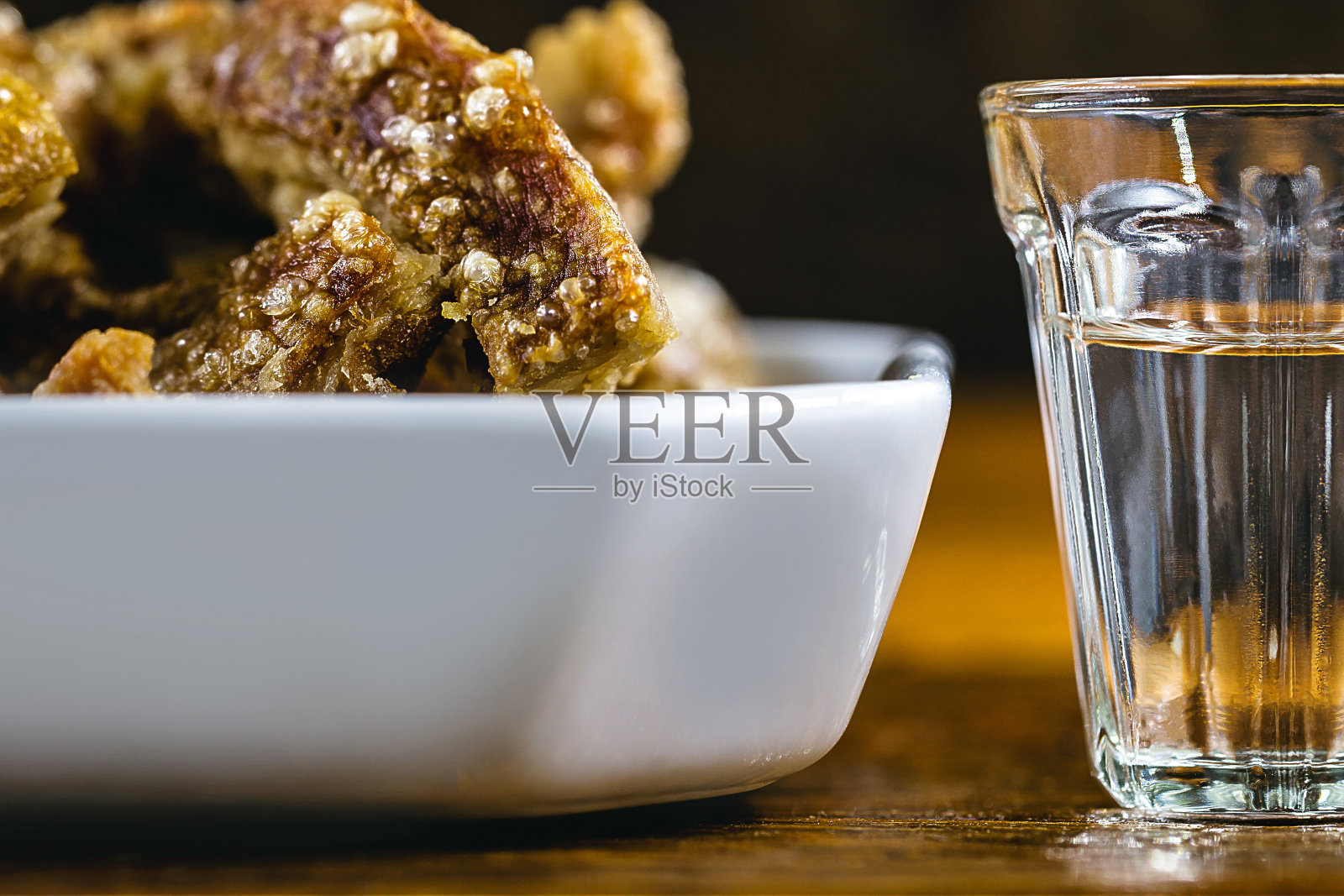 Cachaça, drops, cane or sugar cane is the name given to brandy produced in Brazil. Served with pork crackling. Typical food and drinks from Brazilian restaurants or bars.照片摄影图片