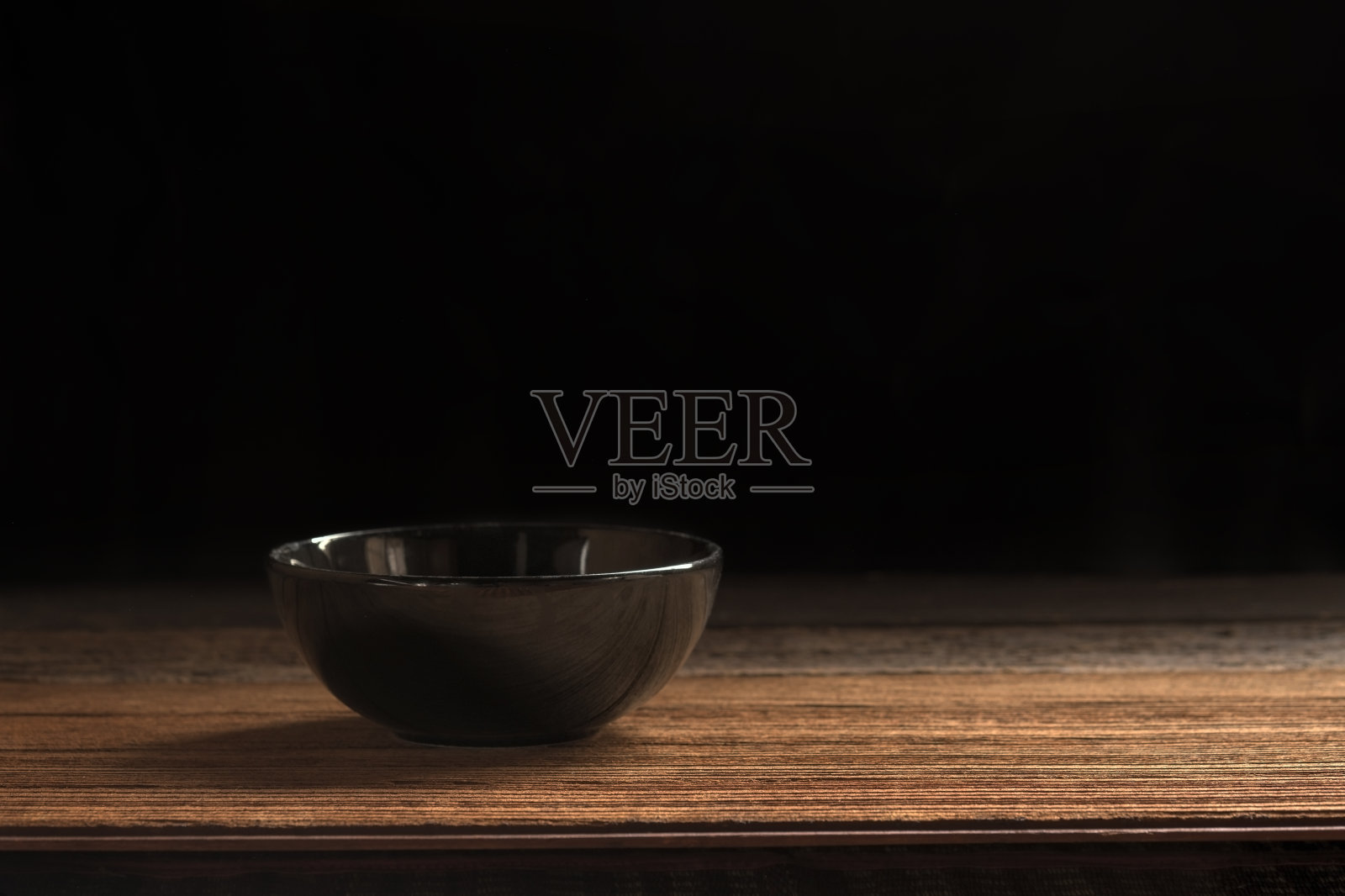 陶瓷黑色碗上的木板和黑色背景介绍菜单和蒙太奇食物的风格。照片摄影图片