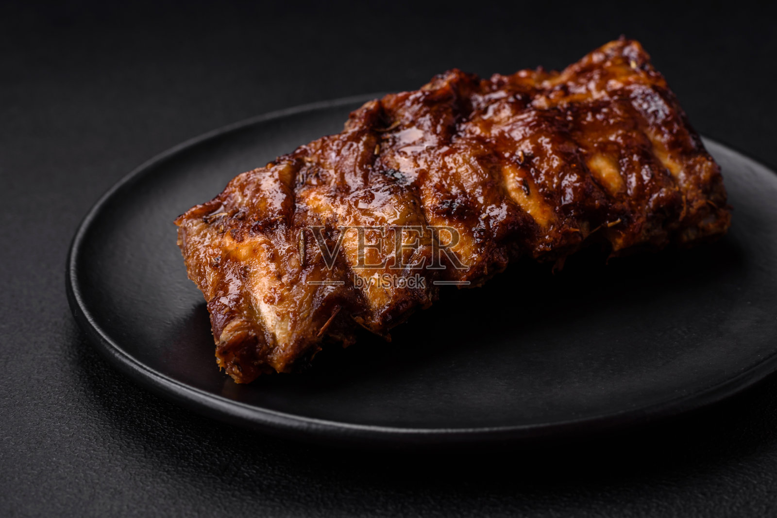 美味的烤排骨配上酱料、香料和香草照片摄影图片