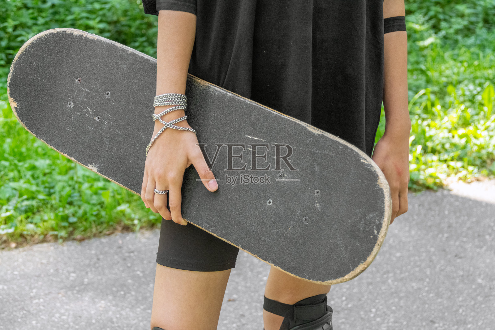 一个无法辨认的年轻滑板手拿着滑板的特写照片摄影图片