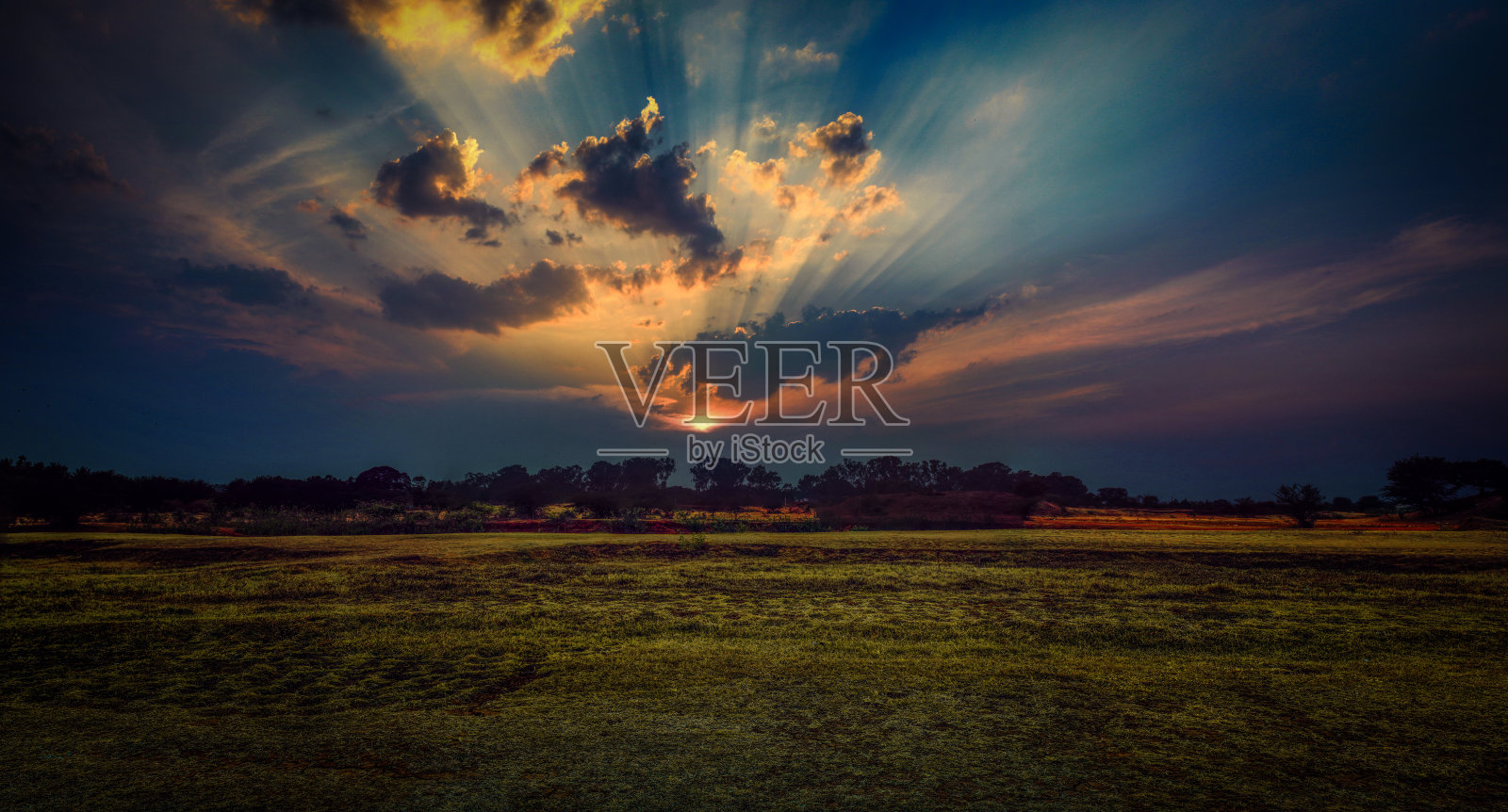 美丽的日落阳光透过云层在田野-股票照片照片摄影图片