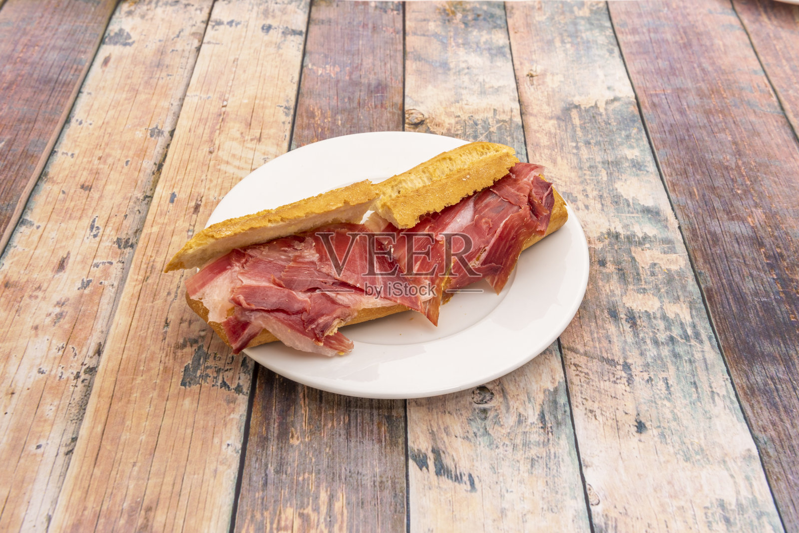 白色盘子里的橡子火腿三明治照片摄影图片