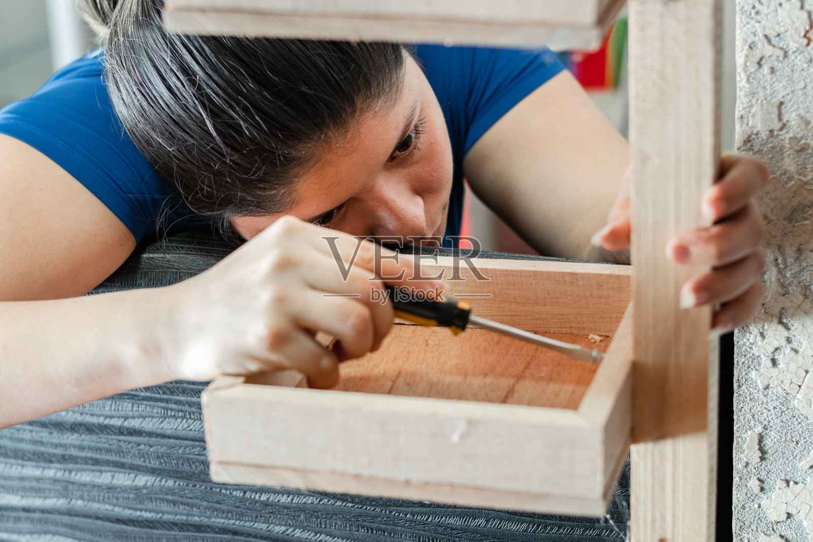 年轻的拉丁女子，聚精会神地看着如何组装木架子照片摄影图片