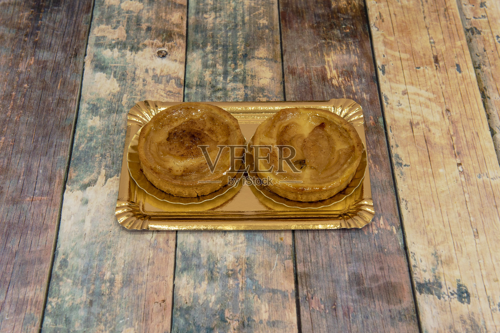 木桌上的苹果馅饼配酥皮、杏果酱和肉桂照片摄影图片