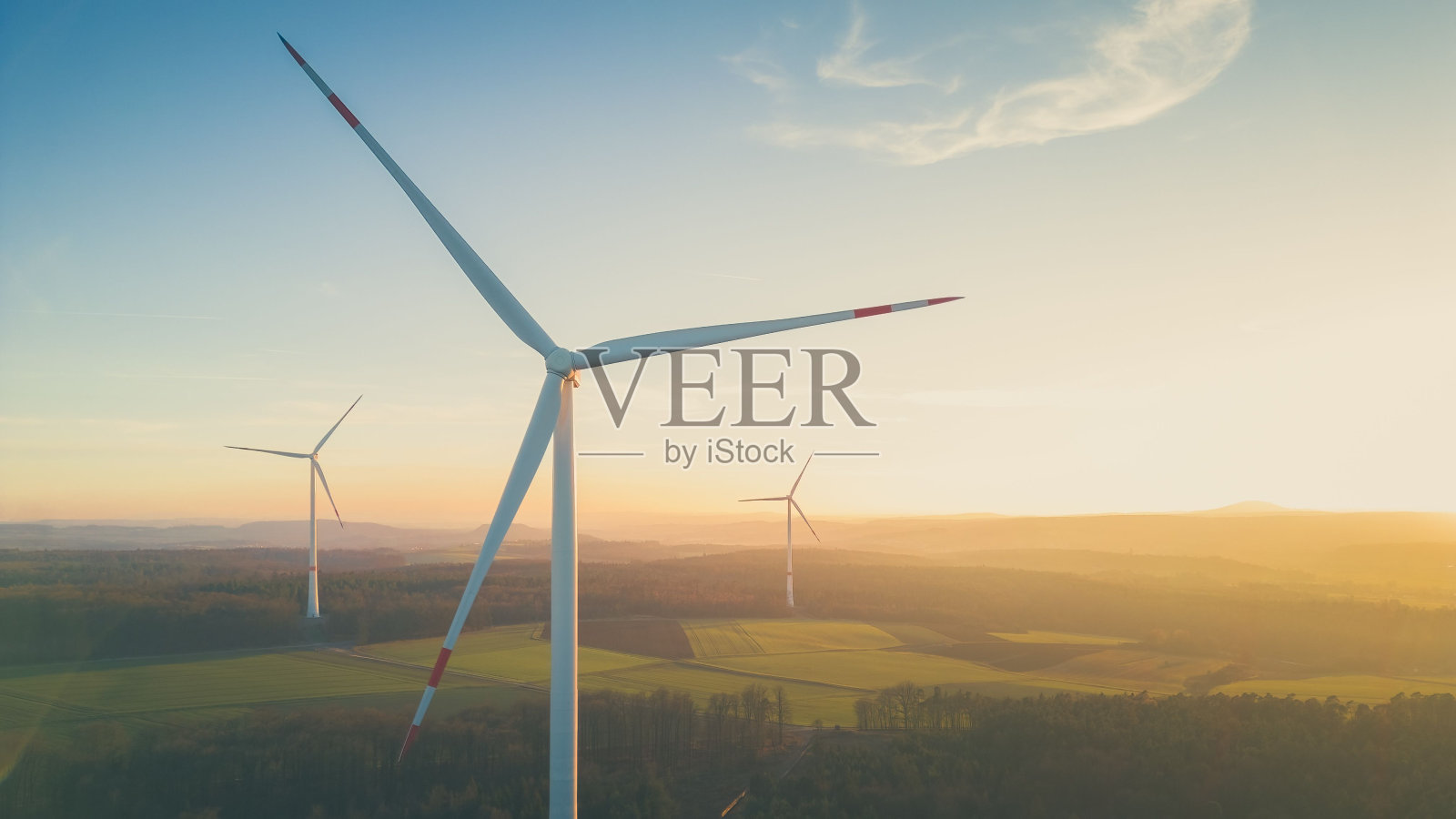 夕阳下的德国乡村，现代风车矗立在农田上照片摄影图片