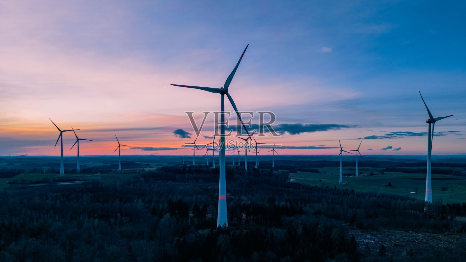 雄伟的风力涡轮机并排矗立在德国美丽的金色日落中照片摄影图片
