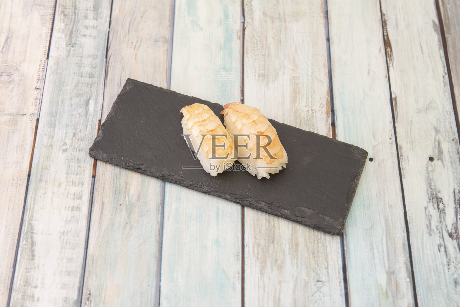 一盘切得好的生鱼片简直是与众不同。上面放一条鱼的饭团被称为NIGIRI寿司。nigiri在日语中的意思是拳头照片摄影图片