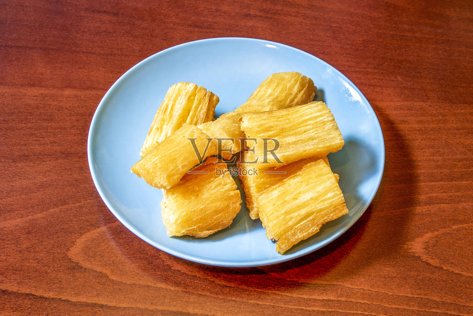 美味的加勒比木薯片，在蓝色的盘子里用橄榄油煎熟照片摄影图片