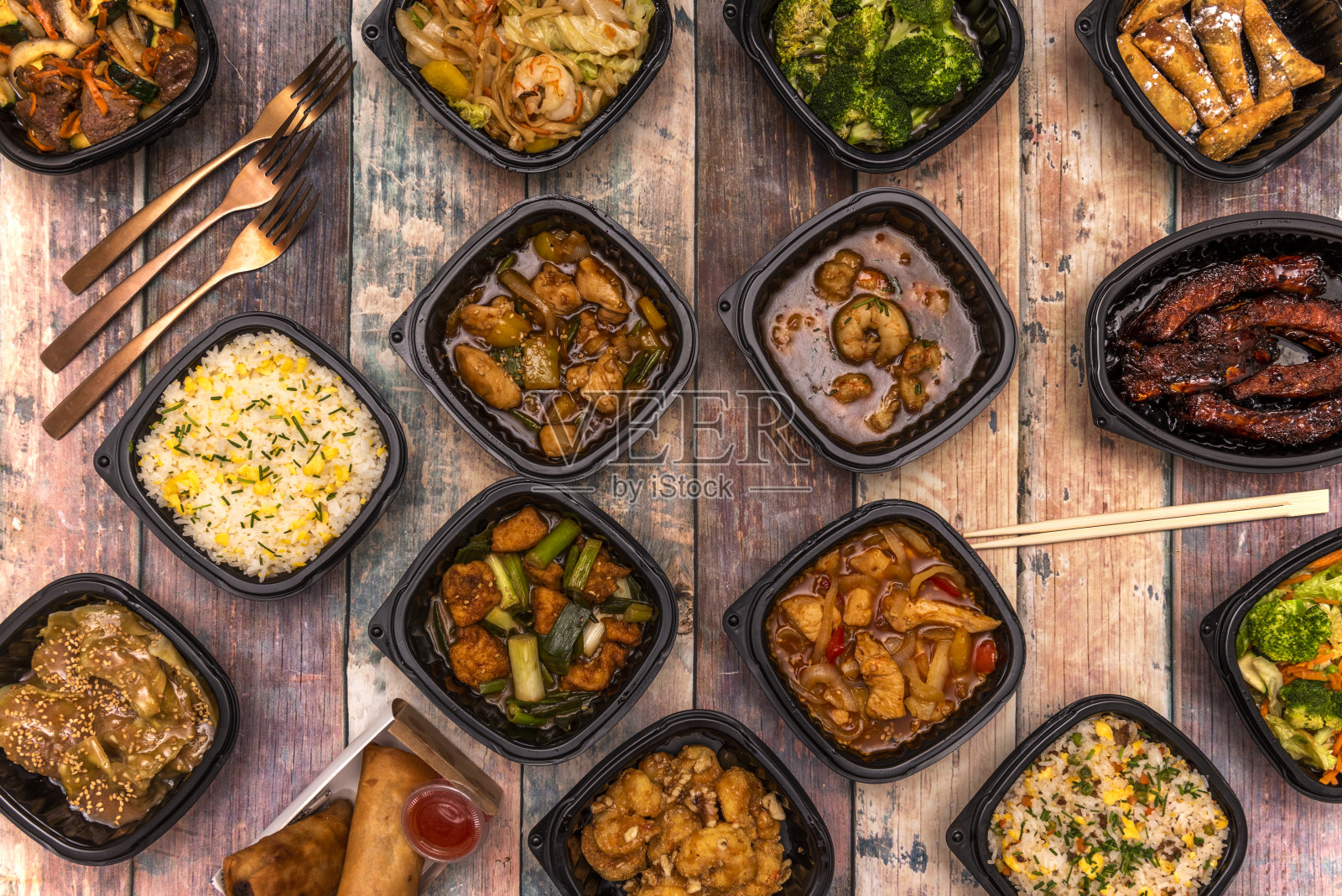 一套亚洲食品食谱在黑色运输容器与筷子和铜餐具照片摄影图片