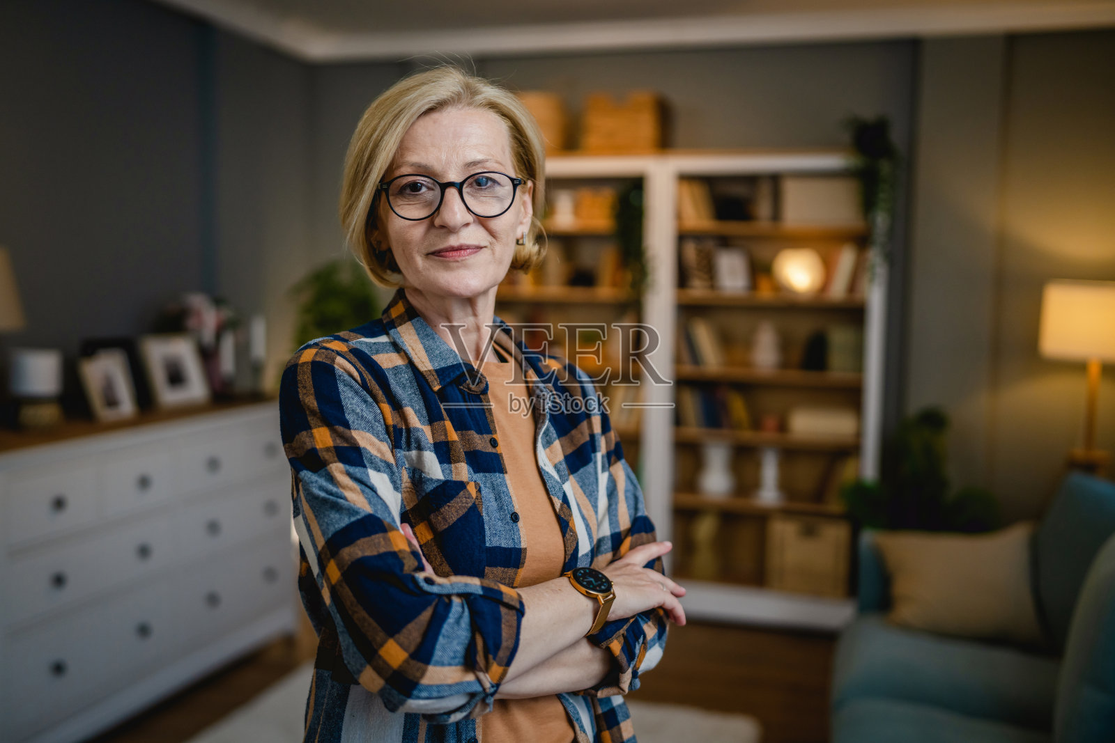 一个成熟的金发白种女人在家里戴着眼镜的肖像照片摄影图片