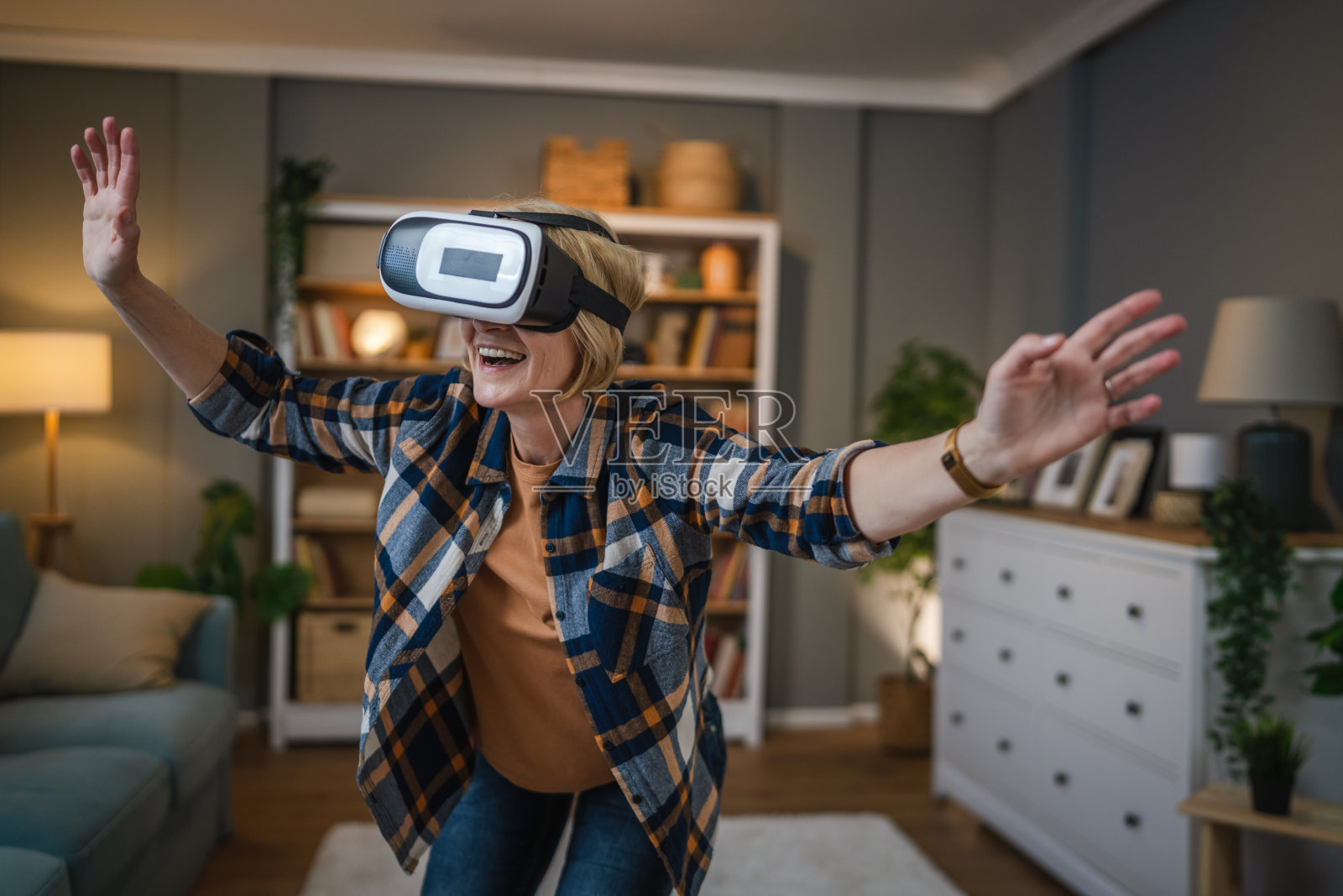 女性成熟老年女性在家享受虚拟现实VR耳机照片摄影图片