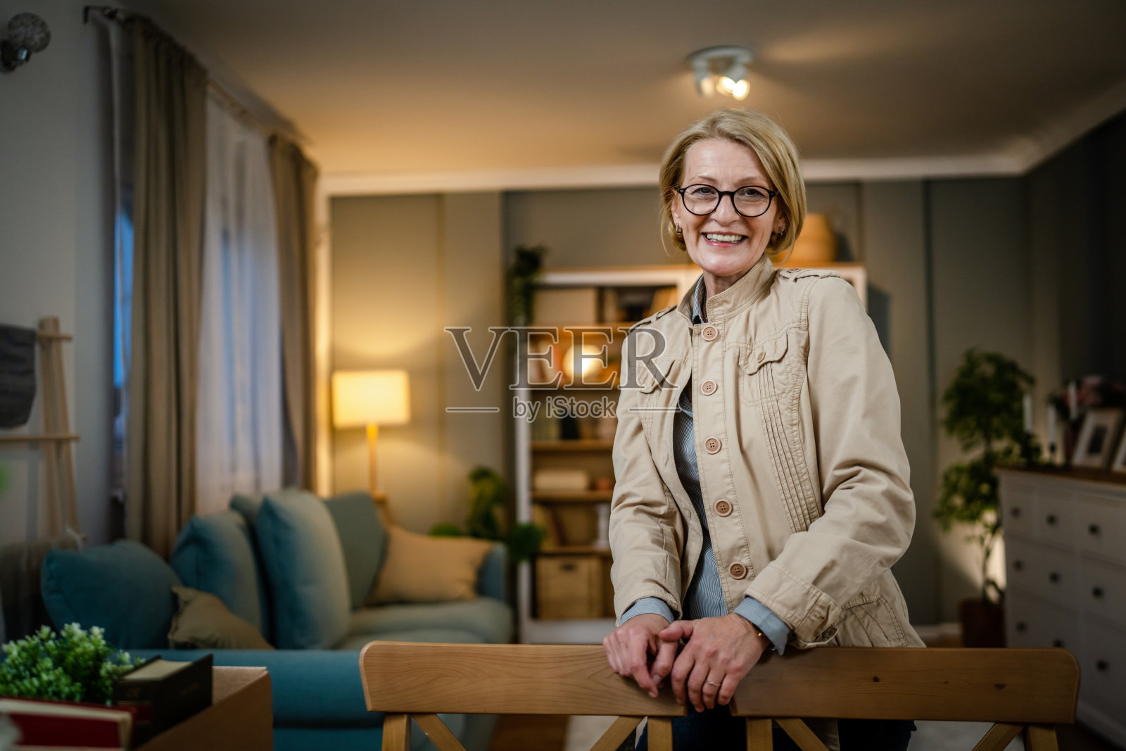 一个成熟的金发白种女人在家里戴着眼镜的肖像照片摄影图片