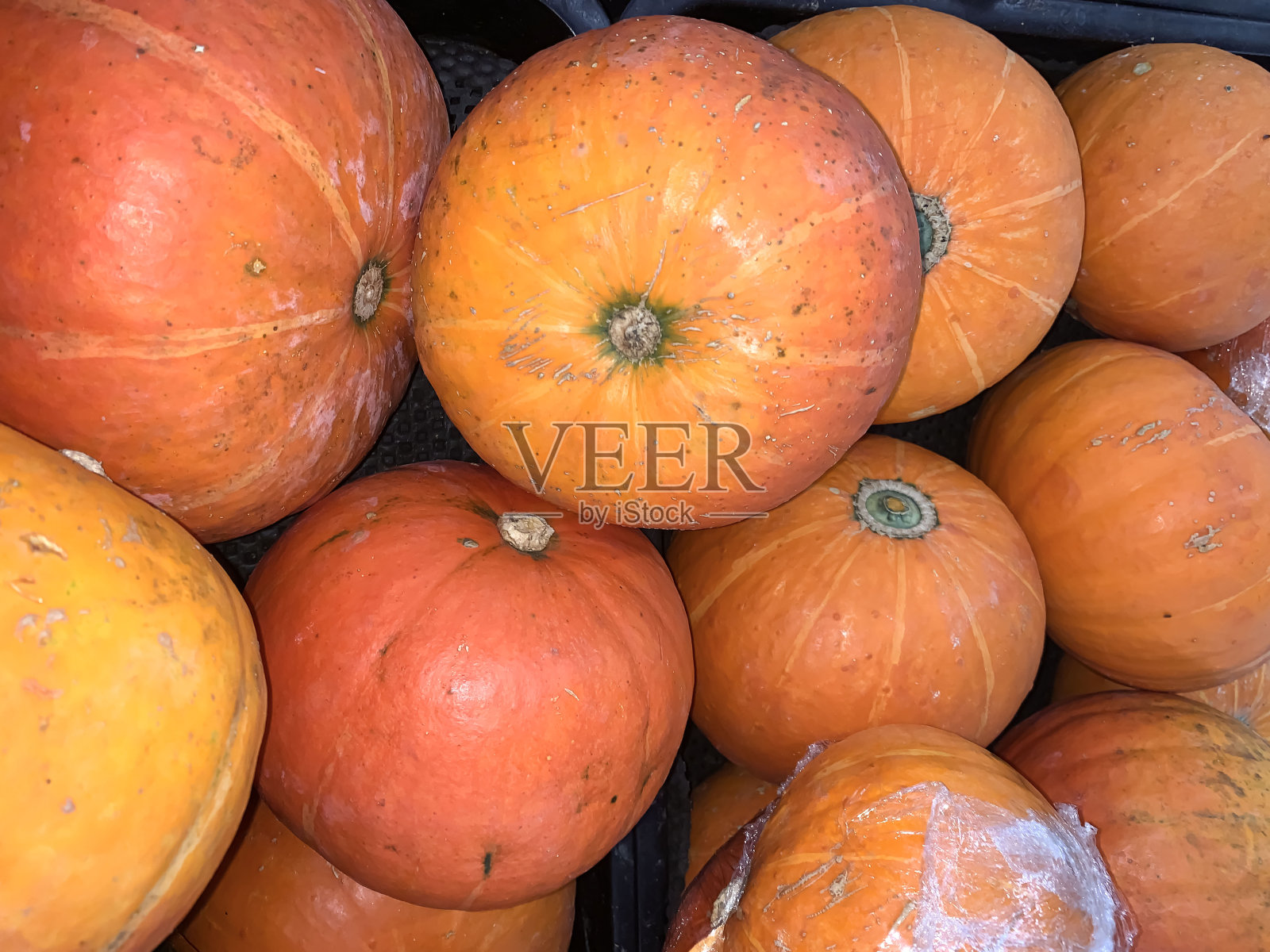 在爪哇的一个农贸市场上展示的装饰性橙色南瓜。阳光下的橙色装饰南瓜照片摄影图片