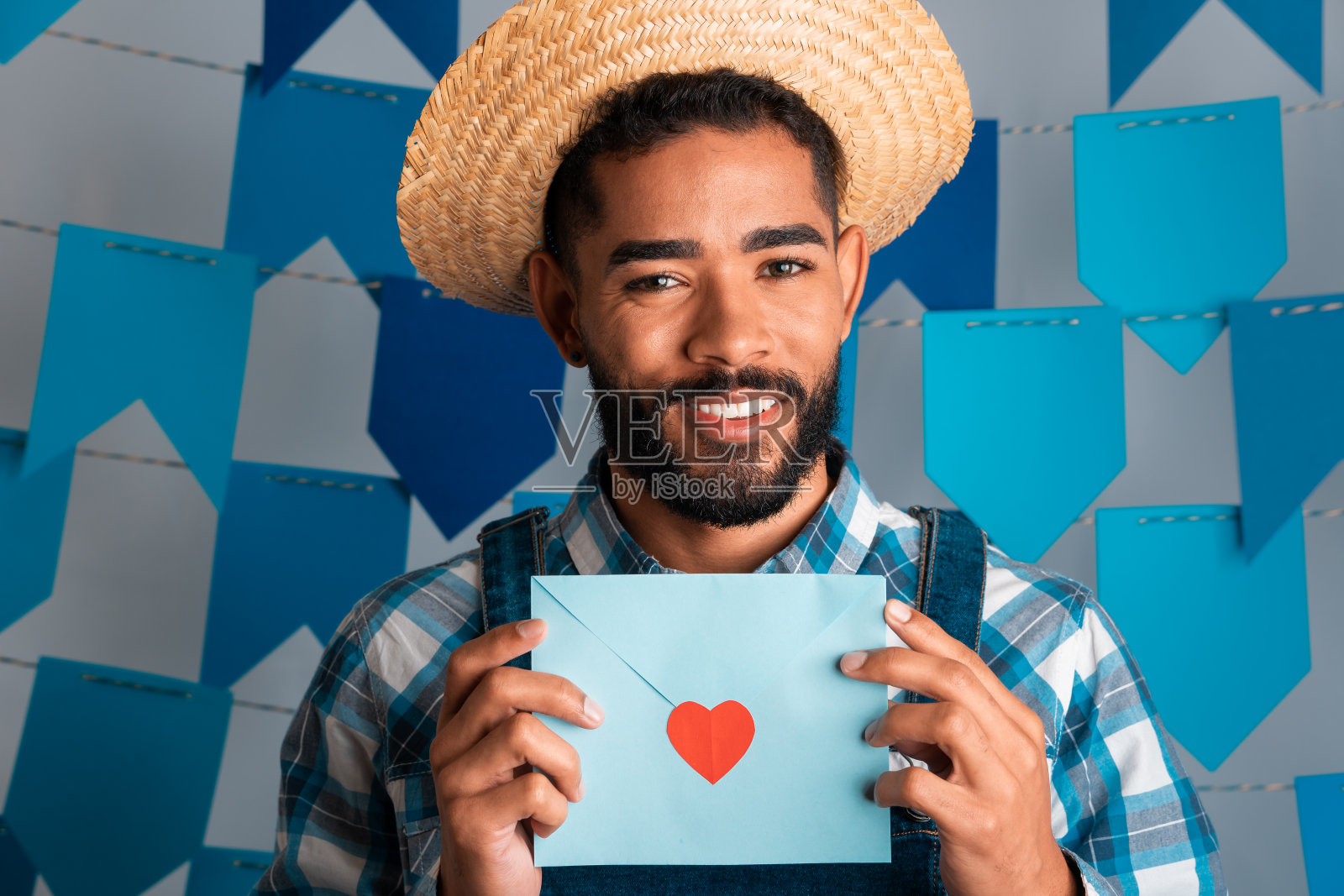 巴西节日朱尼纳，一个积极的男人在六月的派对上穿着传统服装拿着情书照片摄影图片