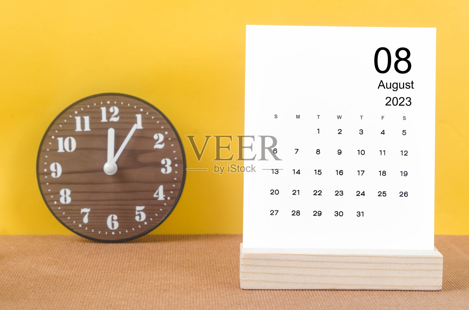 2023年8月月历，黄色表上的时钟。照片摄影图片