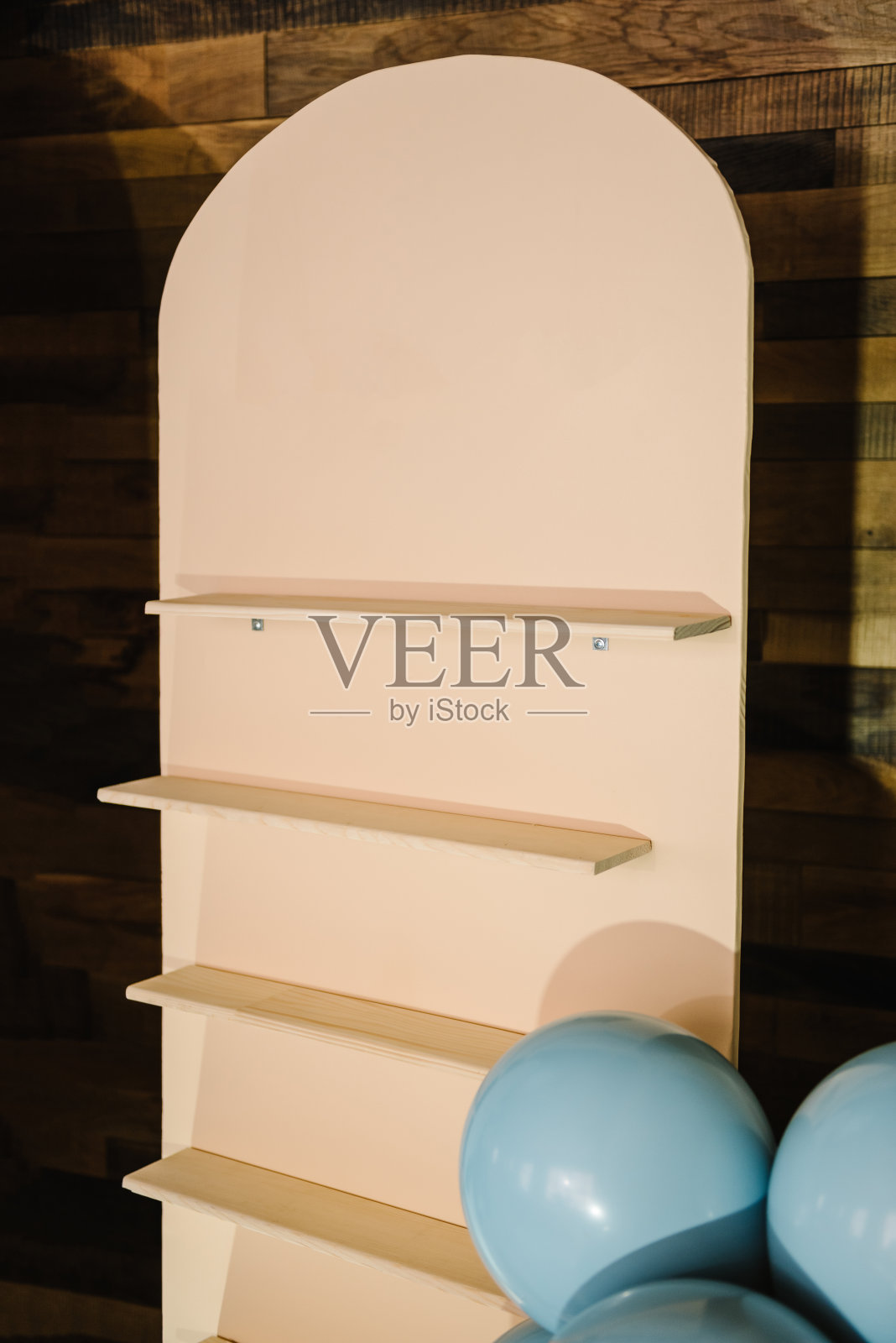 墙上有架子，用来放给男孩的礼物。派对上用蓝气球做的生日装饰。部分拱门和照片墙庆祝儿童活动。文本的空间或位置。特写镜头。照片摄影图片