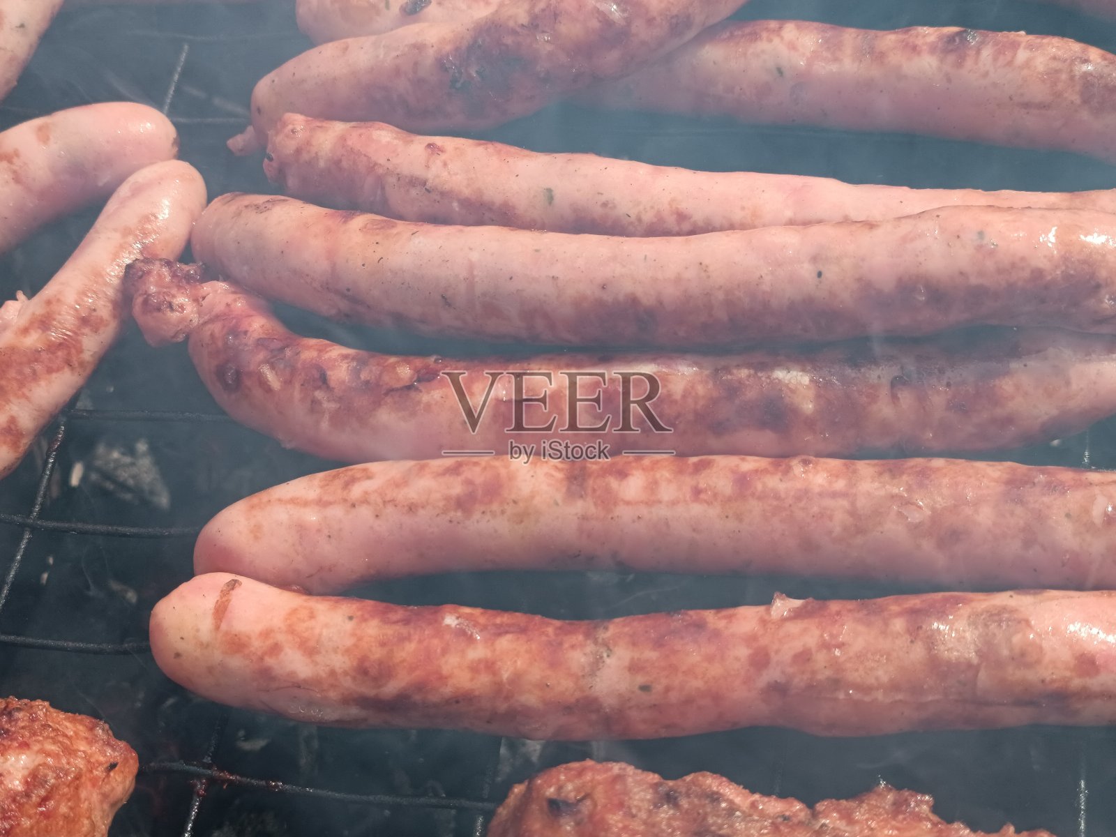 烤香肠。近距离烤架上煎的香肠。软焦点背景。照片摄影图片