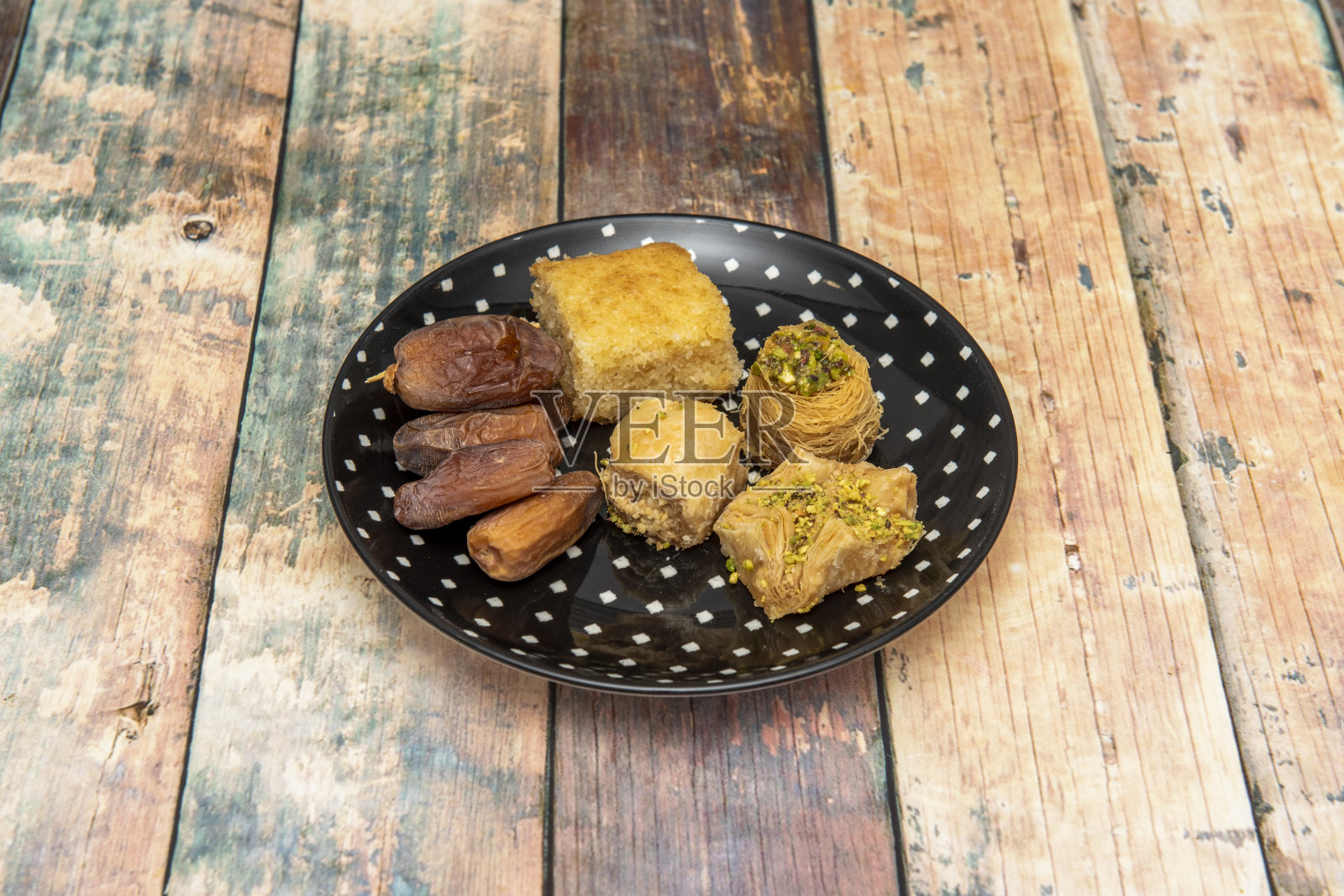 果仁蜜饼是一种用压碎的开心果或核桃做成的面团，涂上糖浆或蜂蜜糖浆、榛子和杏仁以及其他水果。照片摄影图片