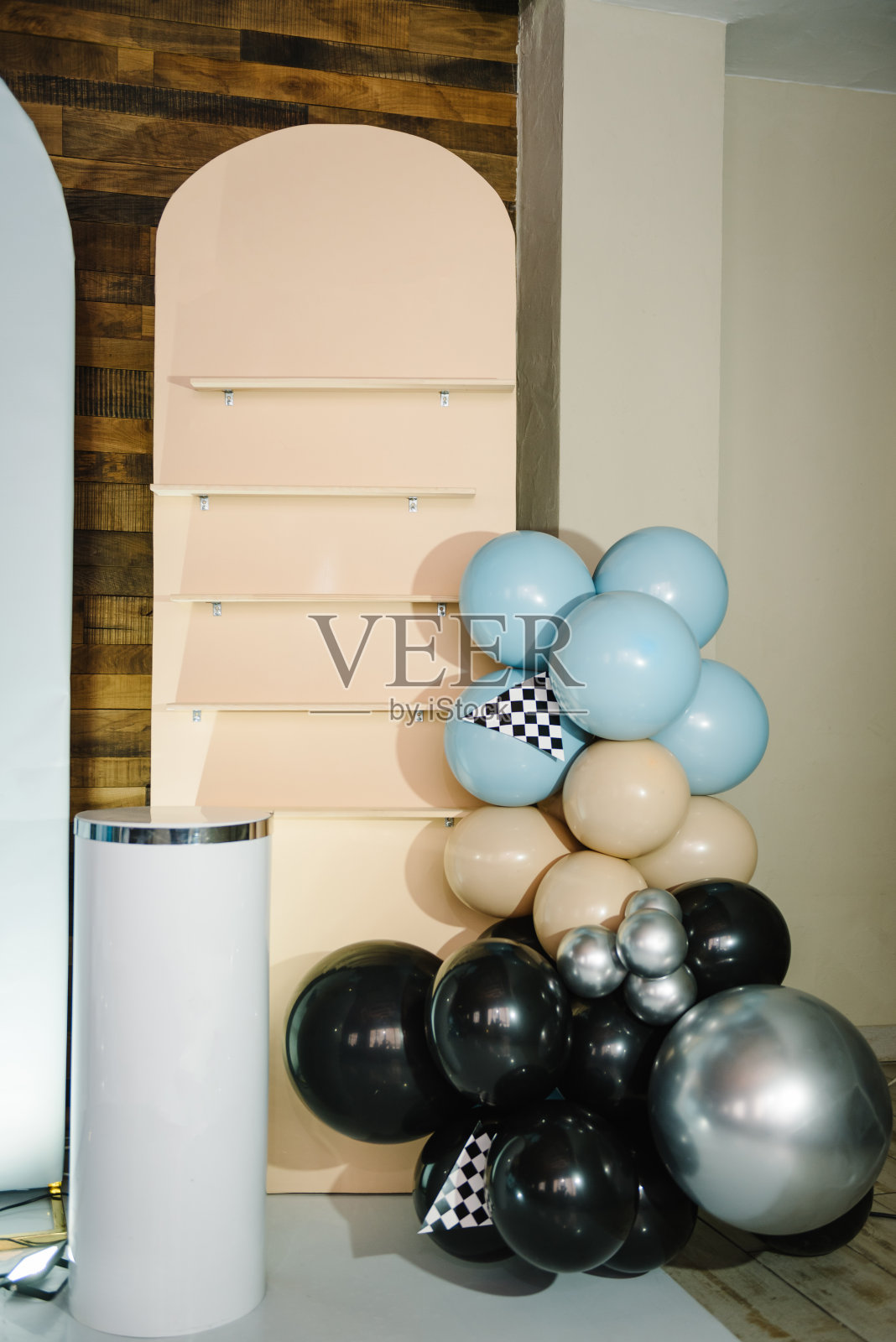 时髦的装饰，带着赛车旗，给男孩开的车。生日装饰用蓝色，棕色，黑色，银色气球为聚会。庆祝活动的拱门。有文字空间或地方的照片墙。放蛋糕的桌子。照片摄影图片