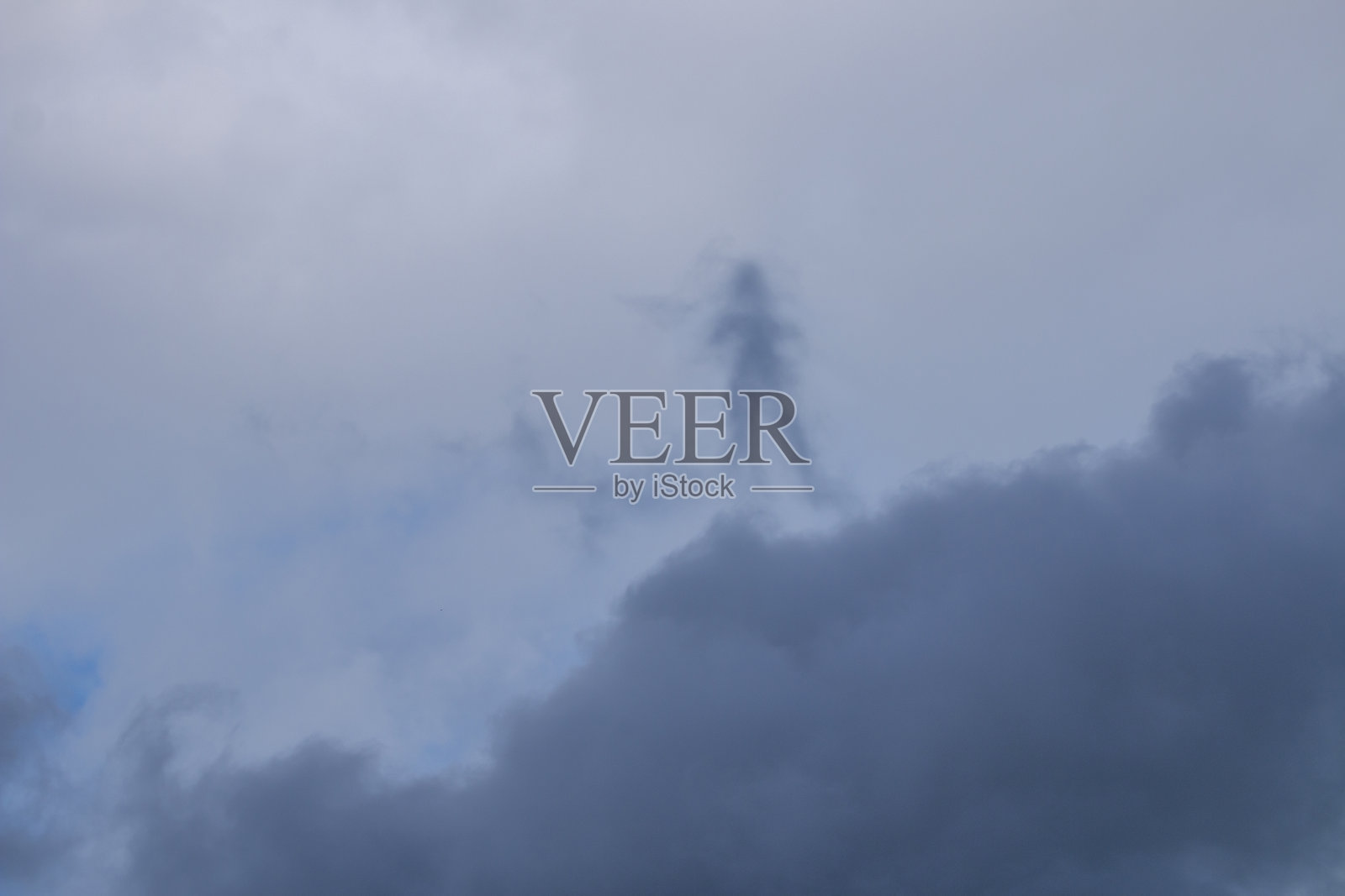 午后天空上灰白色的云朵，有着奇怪的人形。照片摄影图片