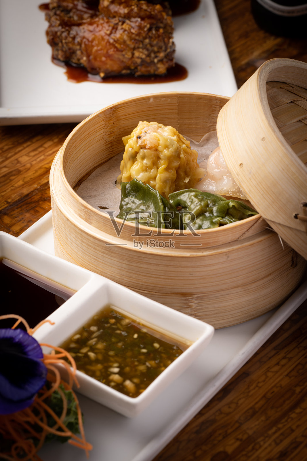 各种各样的日本菜，用新鲜的鱼和新鲜的食材装饰精美，灯光突出了日本料理的鲜艳色彩和纹理照片摄影图片