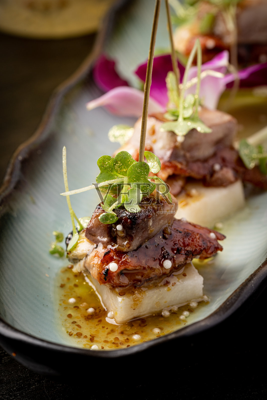 各种各样的日本菜，用新鲜的鱼和新鲜的食材装饰精美，灯光突出了日本料理的鲜艳色彩和纹理照片摄影图片