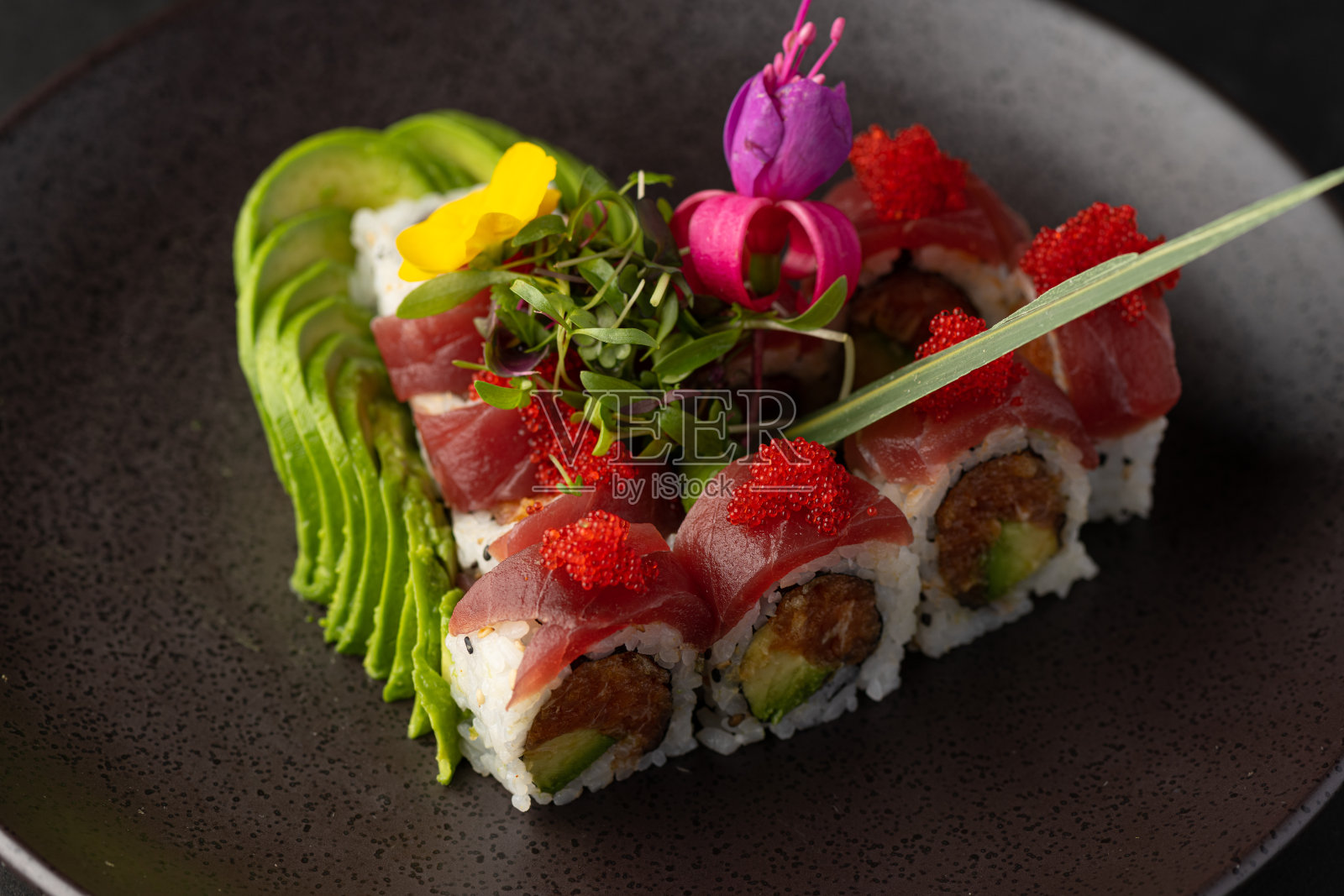 各种各样的日本菜，用新鲜的鱼和新鲜的食材装饰精美，灯光突出了日本料理的鲜艳色彩和纹理照片摄影图片