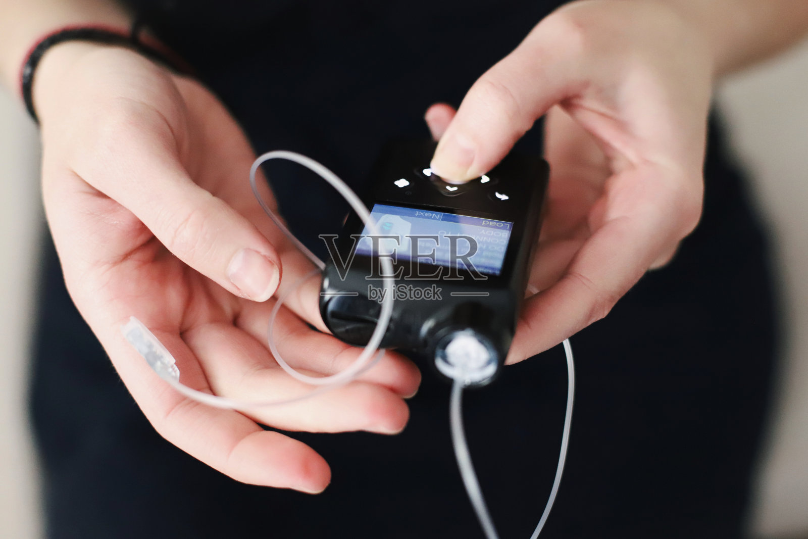 手里拿着胰岛素泵的女人照片摄影图片