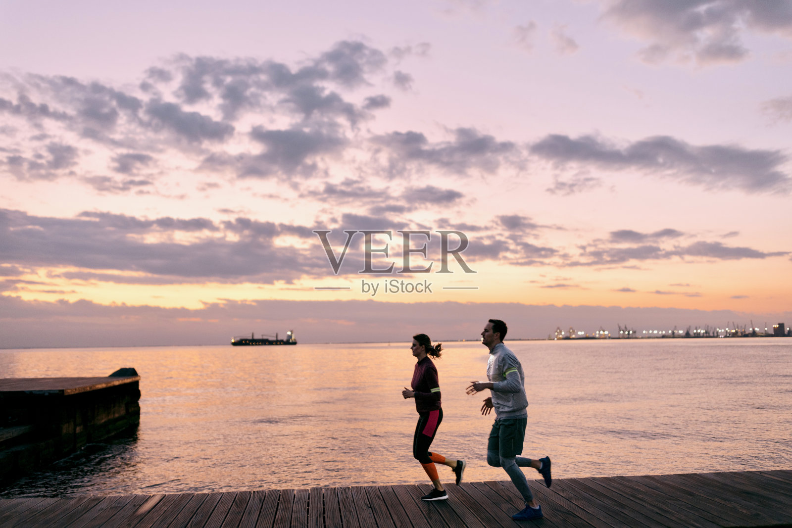 两个人晚上在海边跑步照片摄影图片