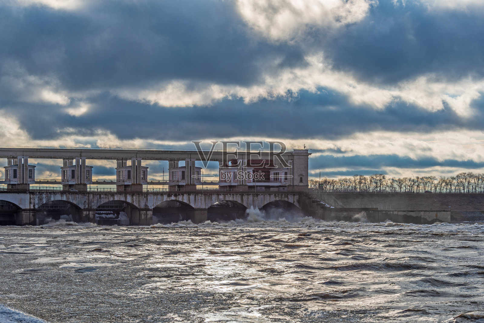 在春季洪水期间从大坝向河上排放的水。照片摄影图片