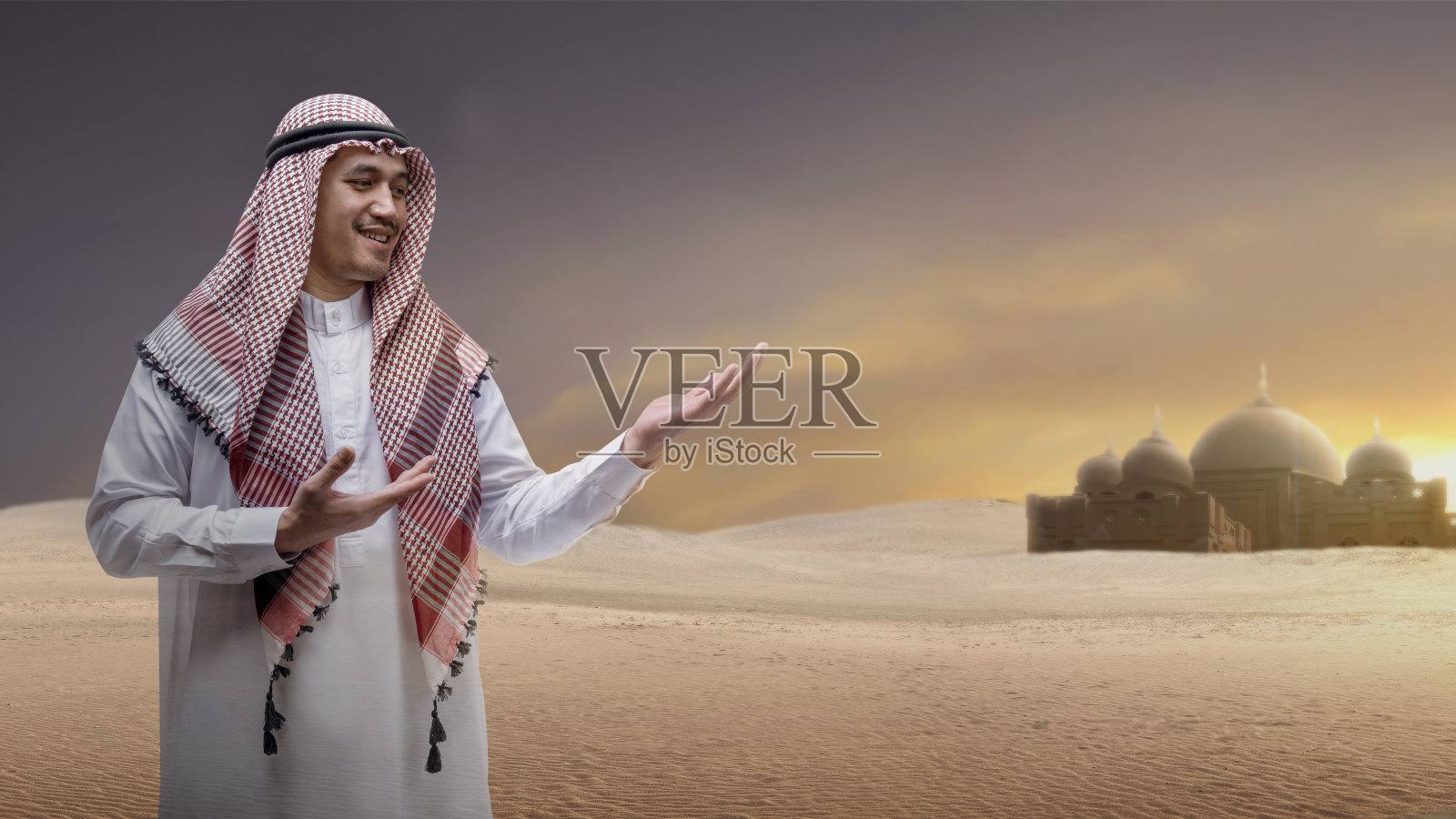 戴着库非耶头巾的阿拉伯男子展示手中的东西照片摄影图片