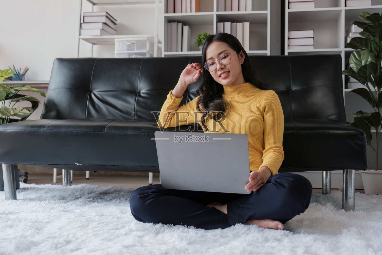 快乐的年轻亚洲女商人成功兴奋地举起手，在家里用笔记本电脑庆祝。照片摄影图片
