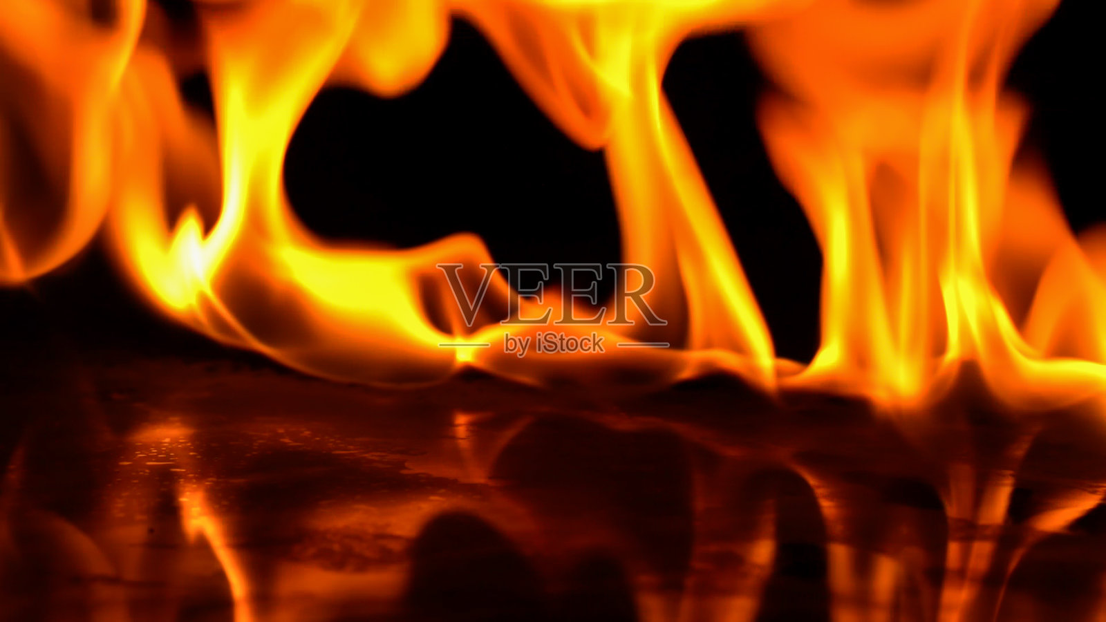 火焰的燃烧力量，火焰和燃烧的火花特写，火焰的图案，黑暗中火焰的光芒。软的焦点。照片摄影图片