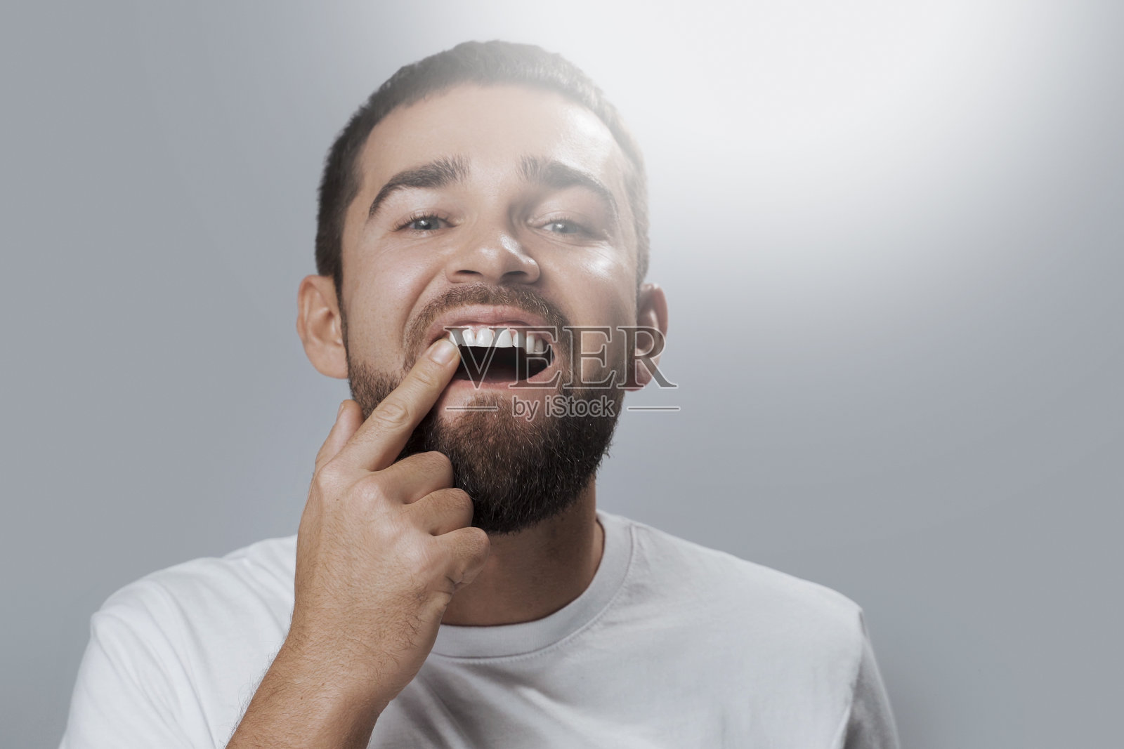 大胡子男子检查牙齿健康状况照片摄影图片