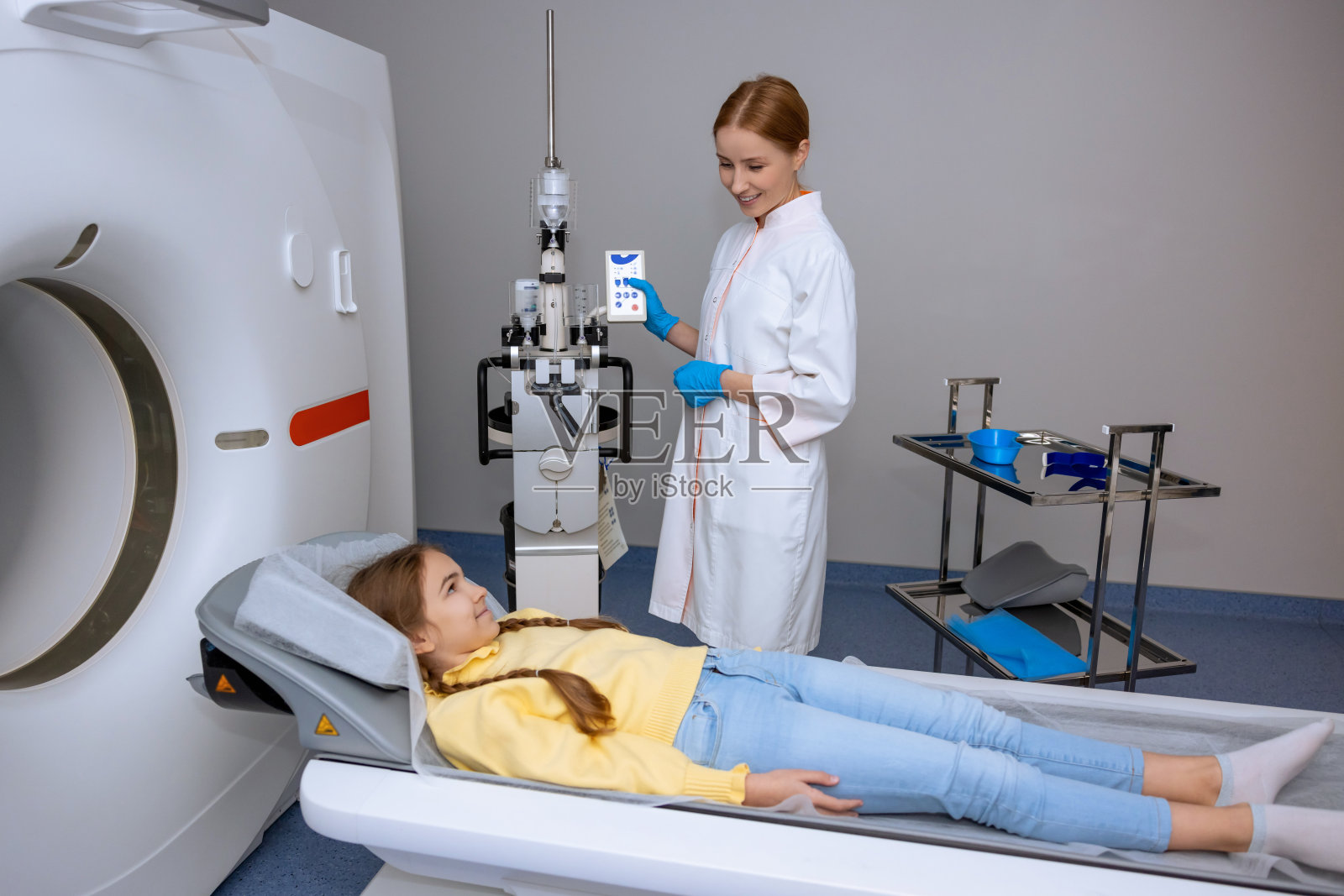 带着辫子的可爱女孩病人准备做ct扫描。照片摄影图片