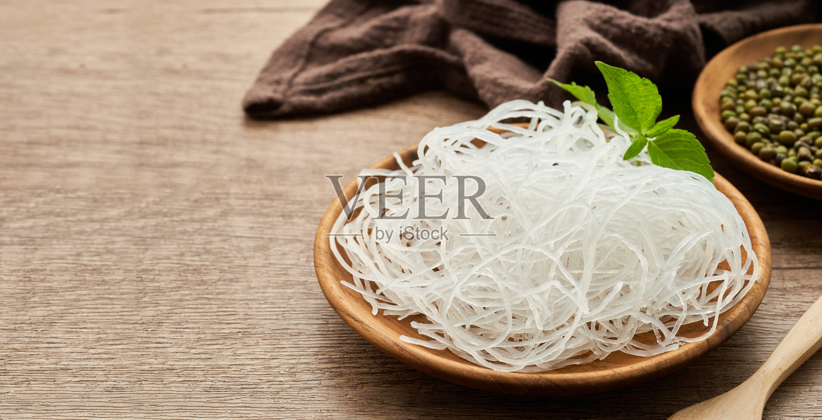 木桌背景木盘上的亚洲粉丝或玻璃纸面和绿豆。玻璃面照片摄影图片